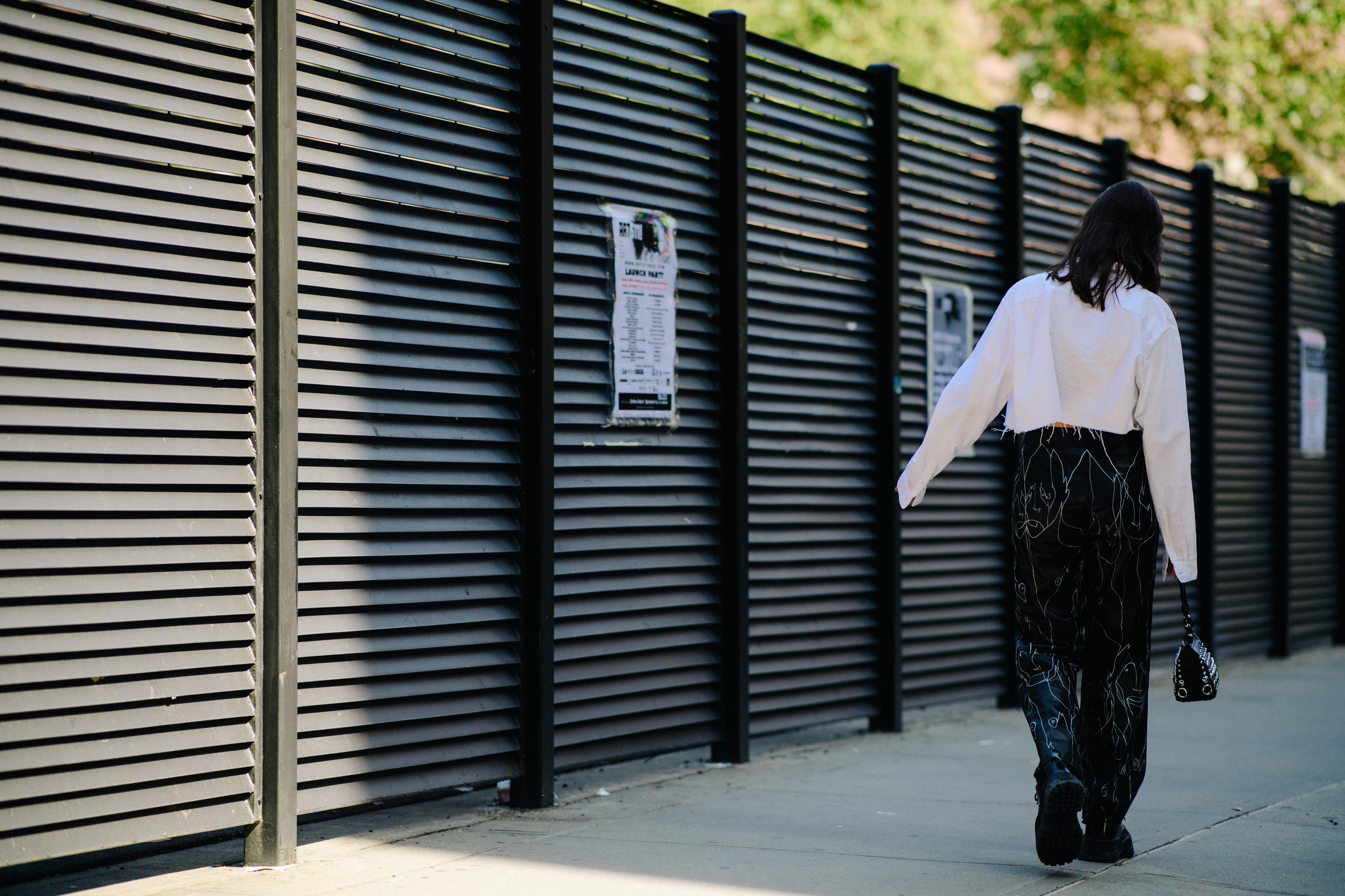 Model wearing white top and black trousers