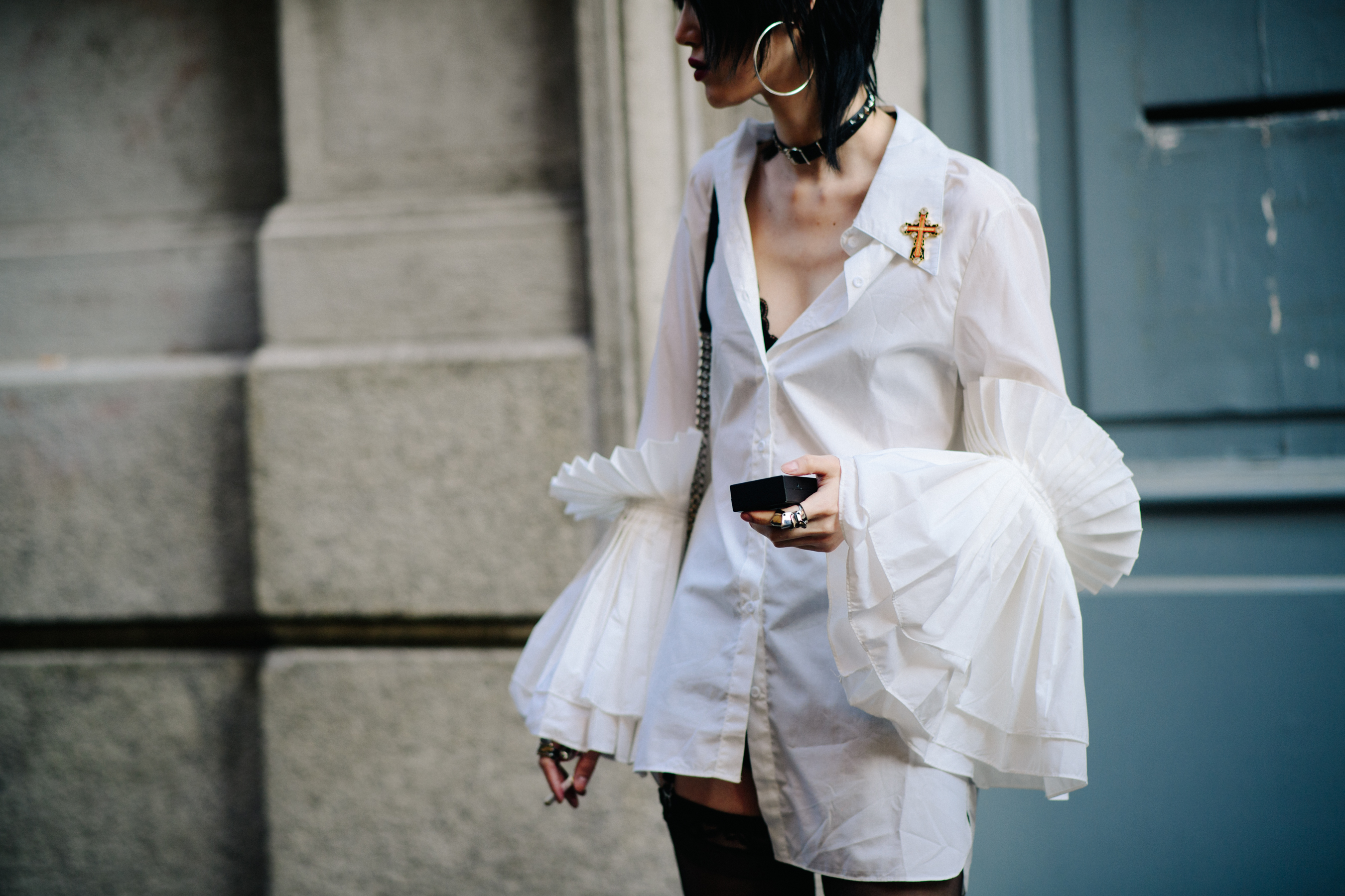 Asian model wearing white shirt with large fanned sleeves