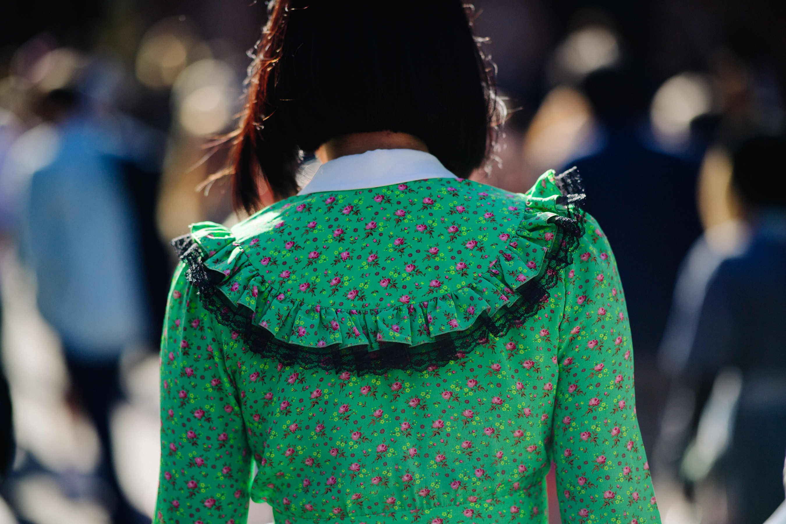 Closeup of back of woman in floral print green dress