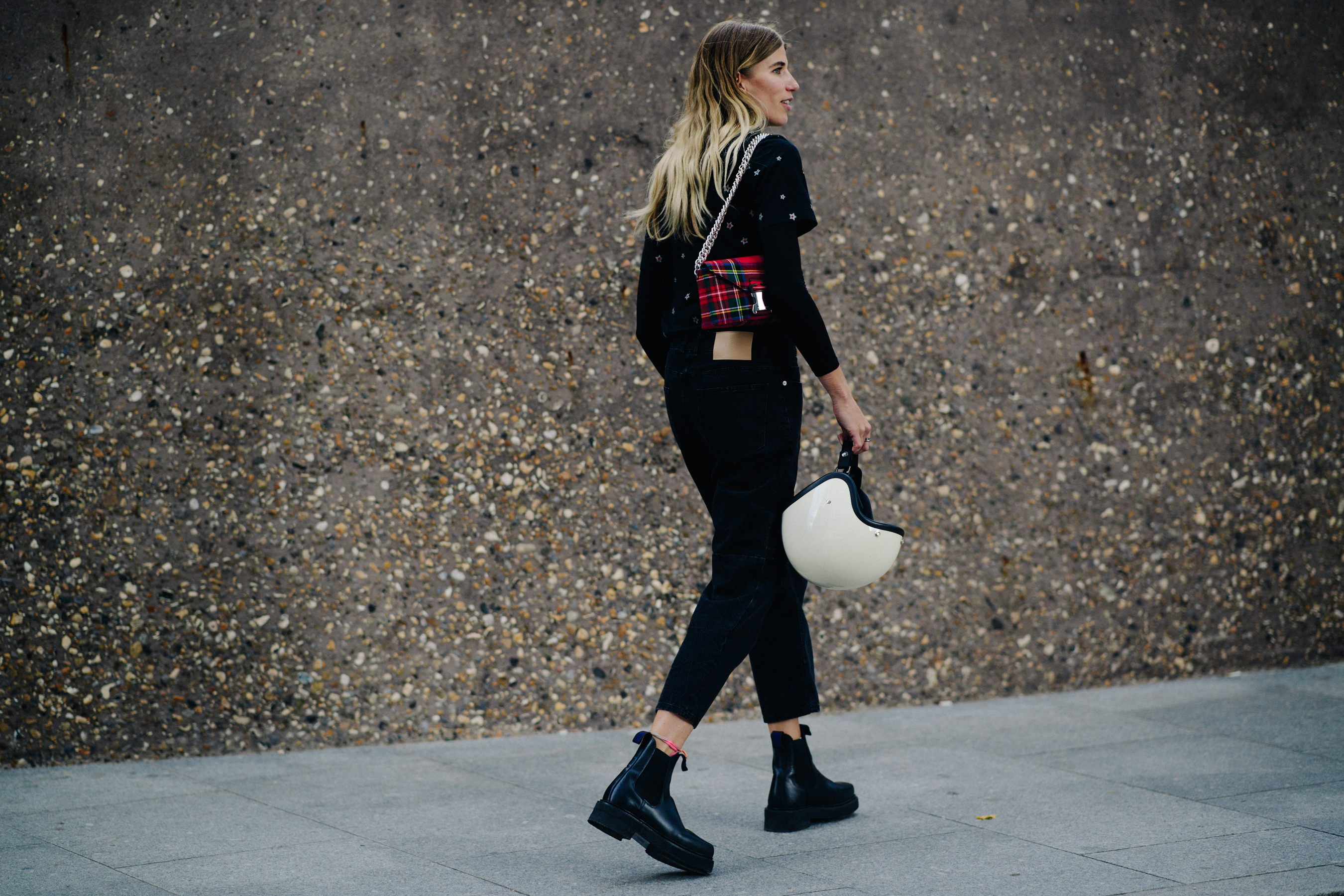 German buyer wearing black jeans and tartan bag