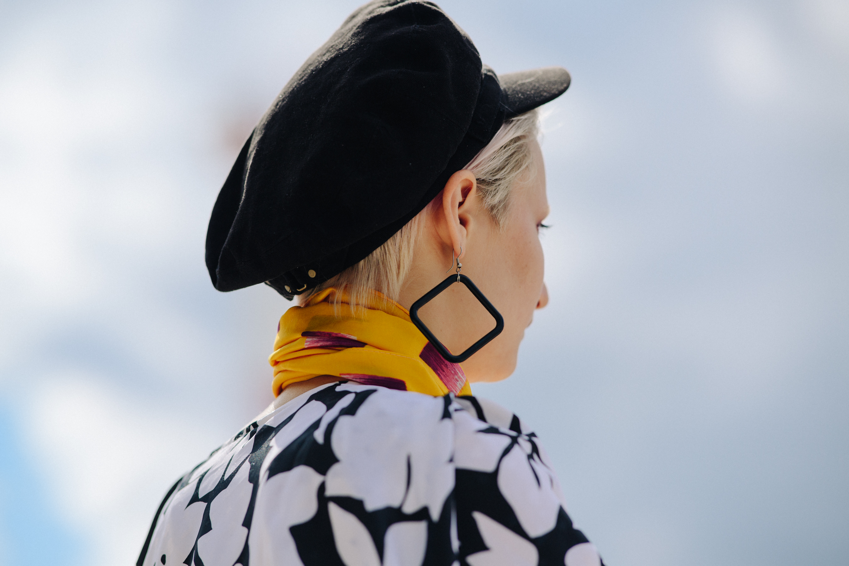 Woman wearing black hat and yellow scarf