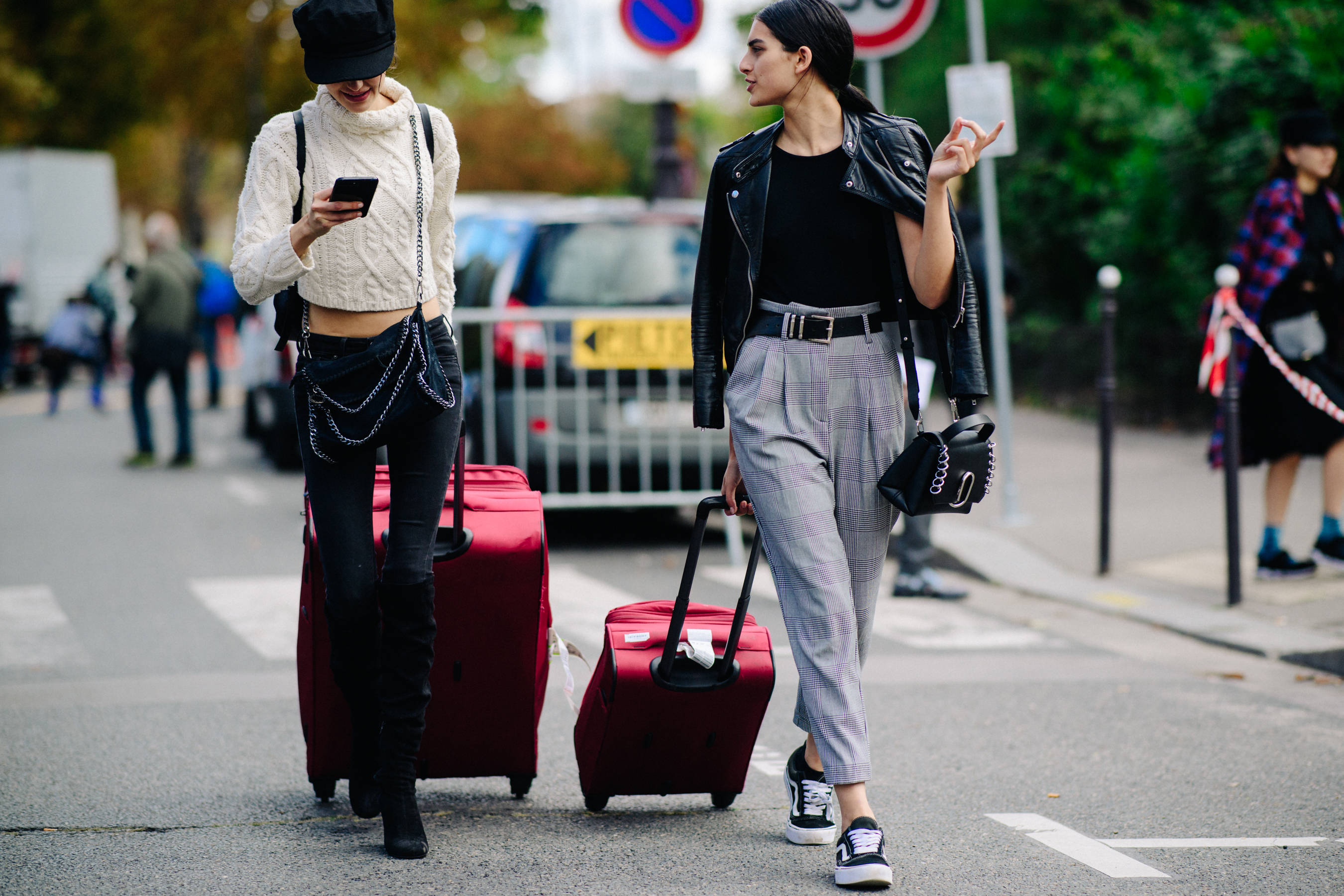 Two women with red suitcases