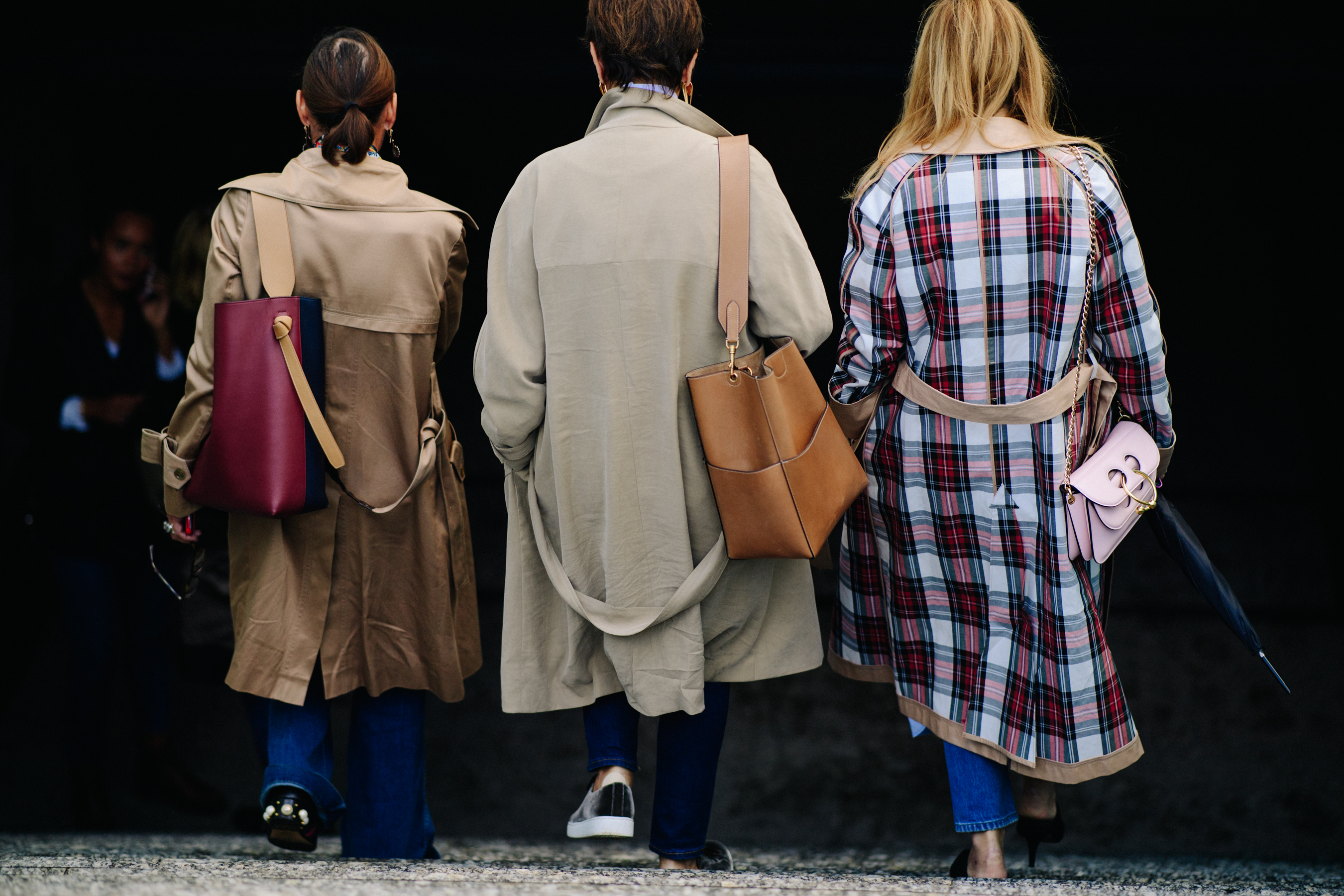 Three women wearing long coat
