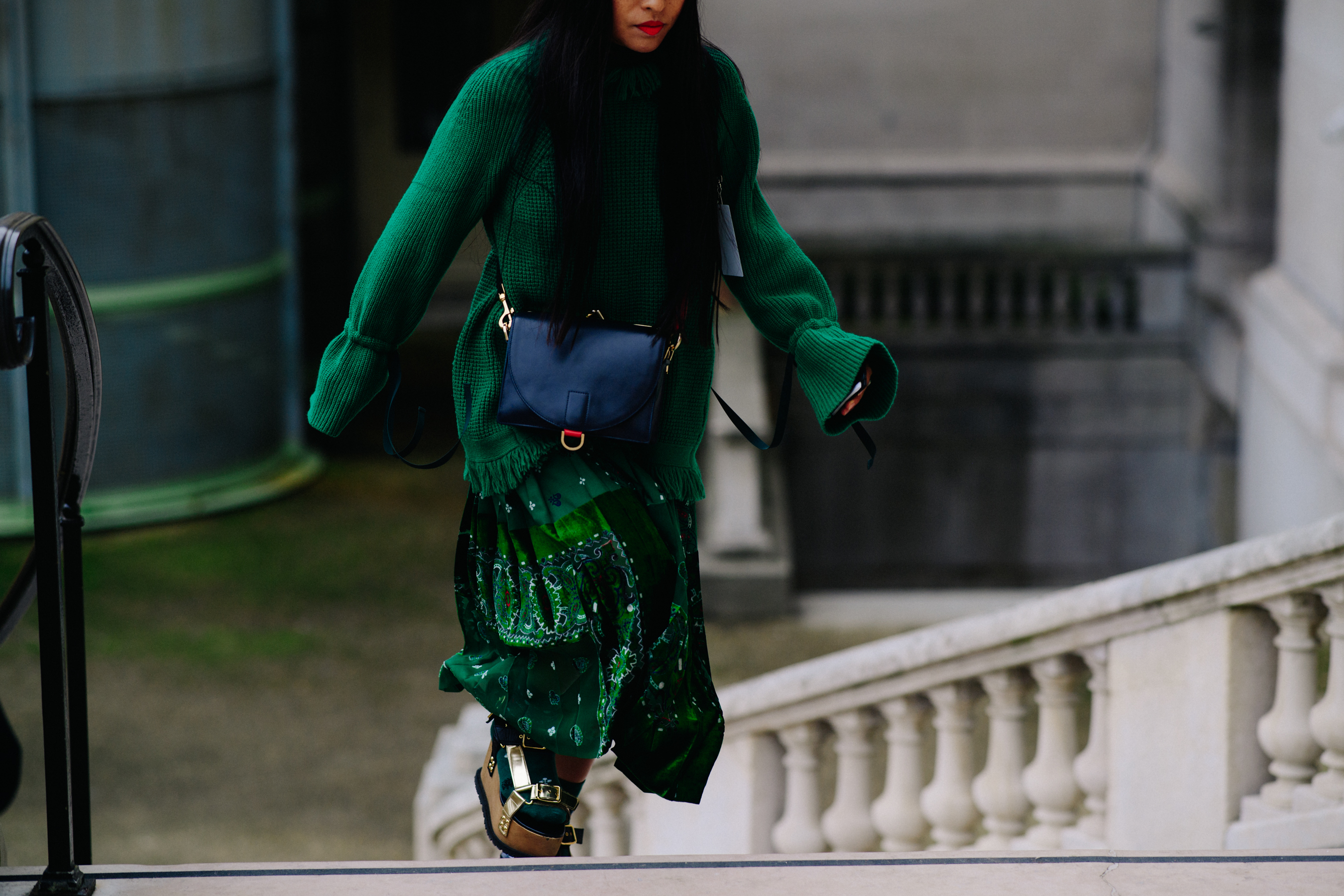 Woman wearing long green Sacai skirt