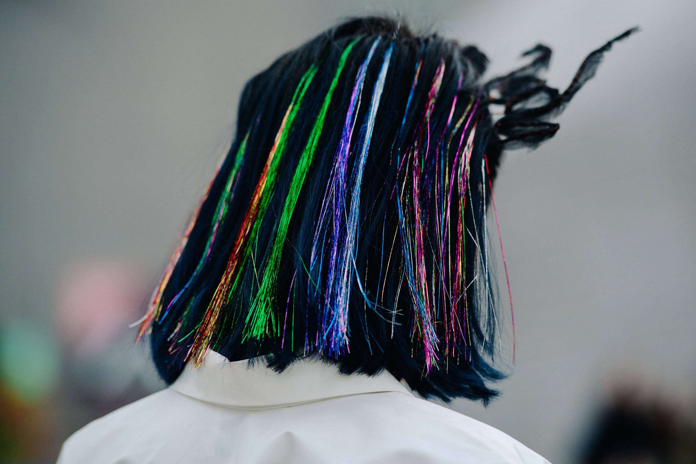 Closeup of back of womans hair with colourful strands