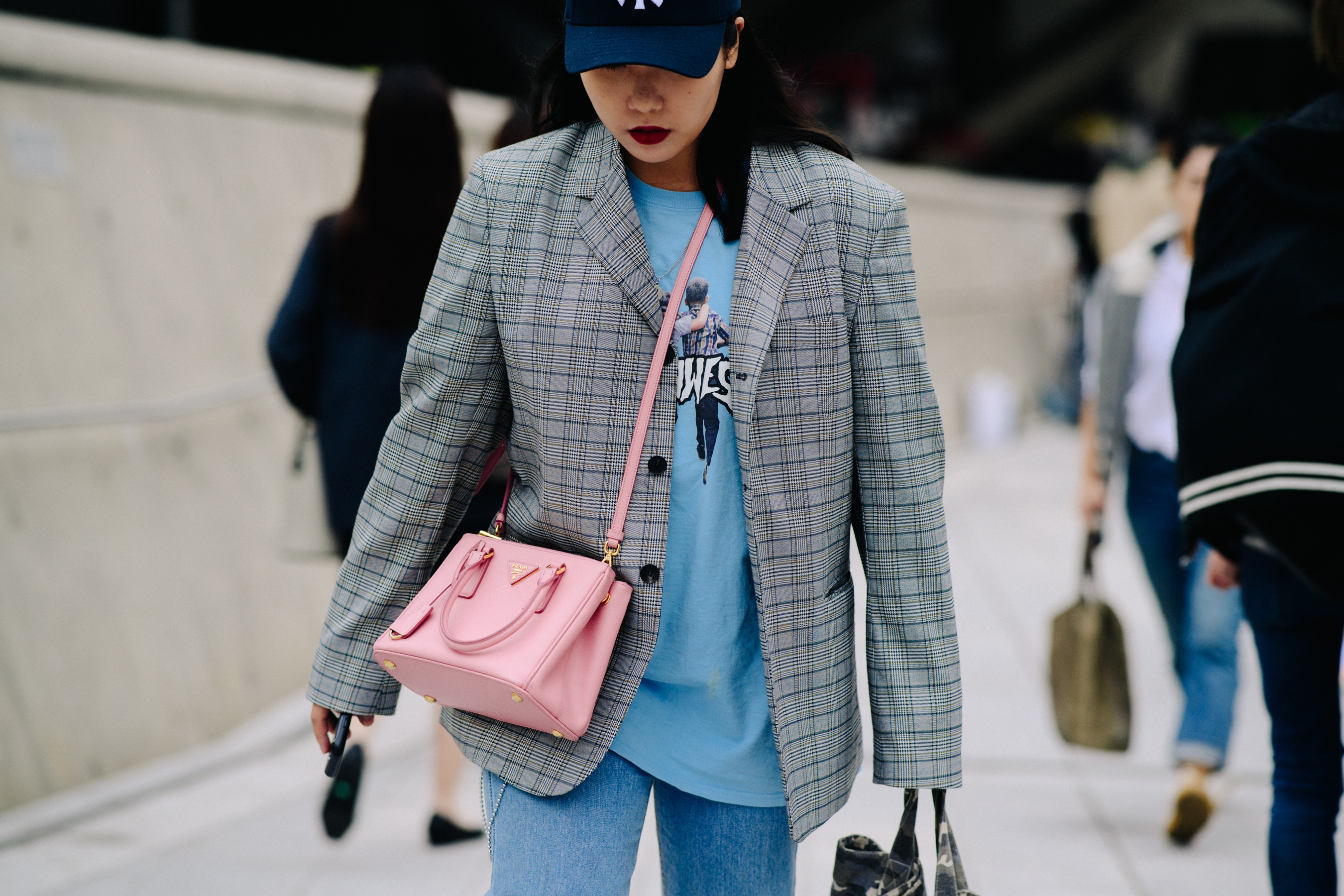 Woman wearing Fucking Awesome! tee shirt and Prada bag