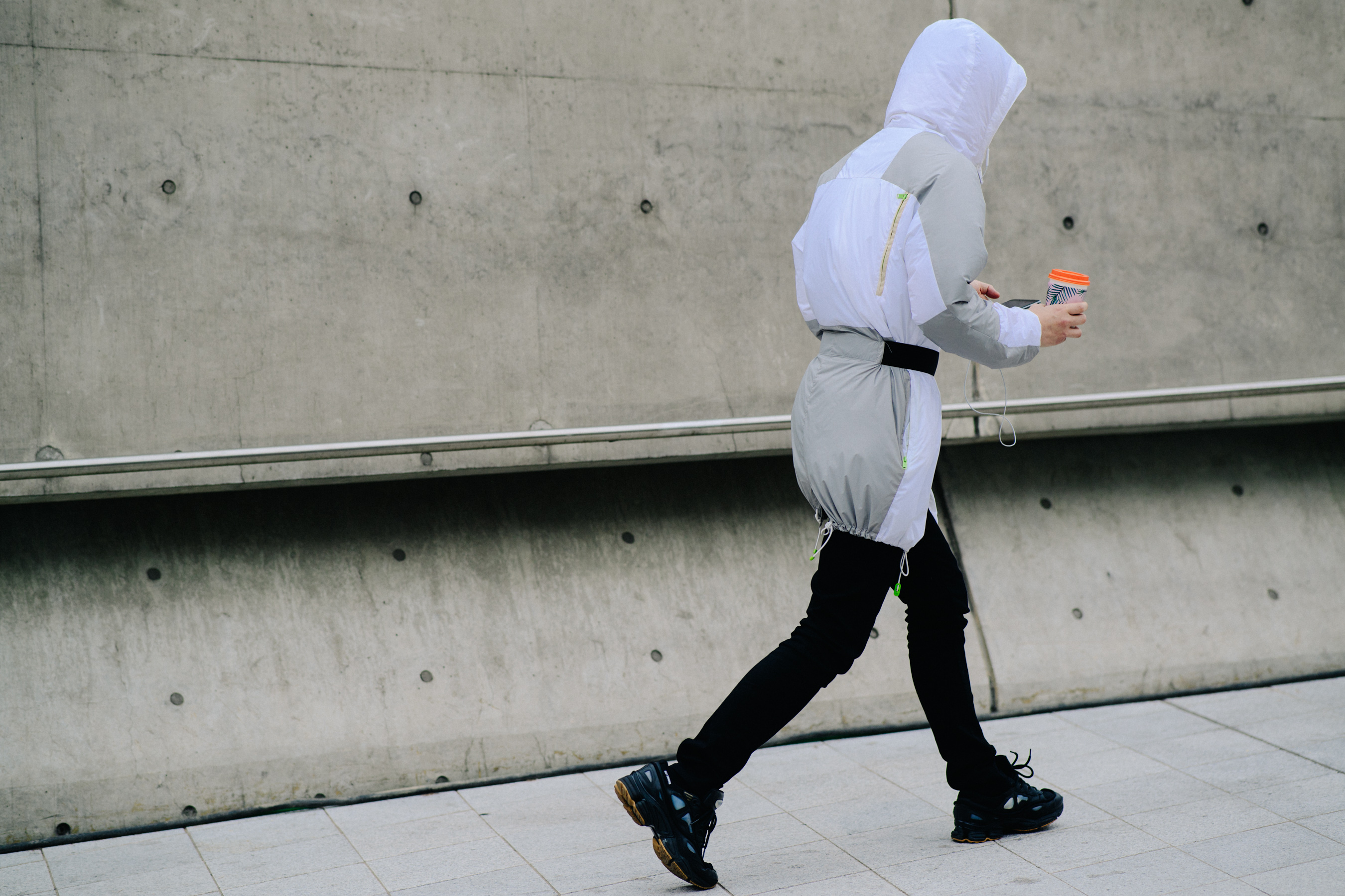 Man walking with hooded white and cream jacket