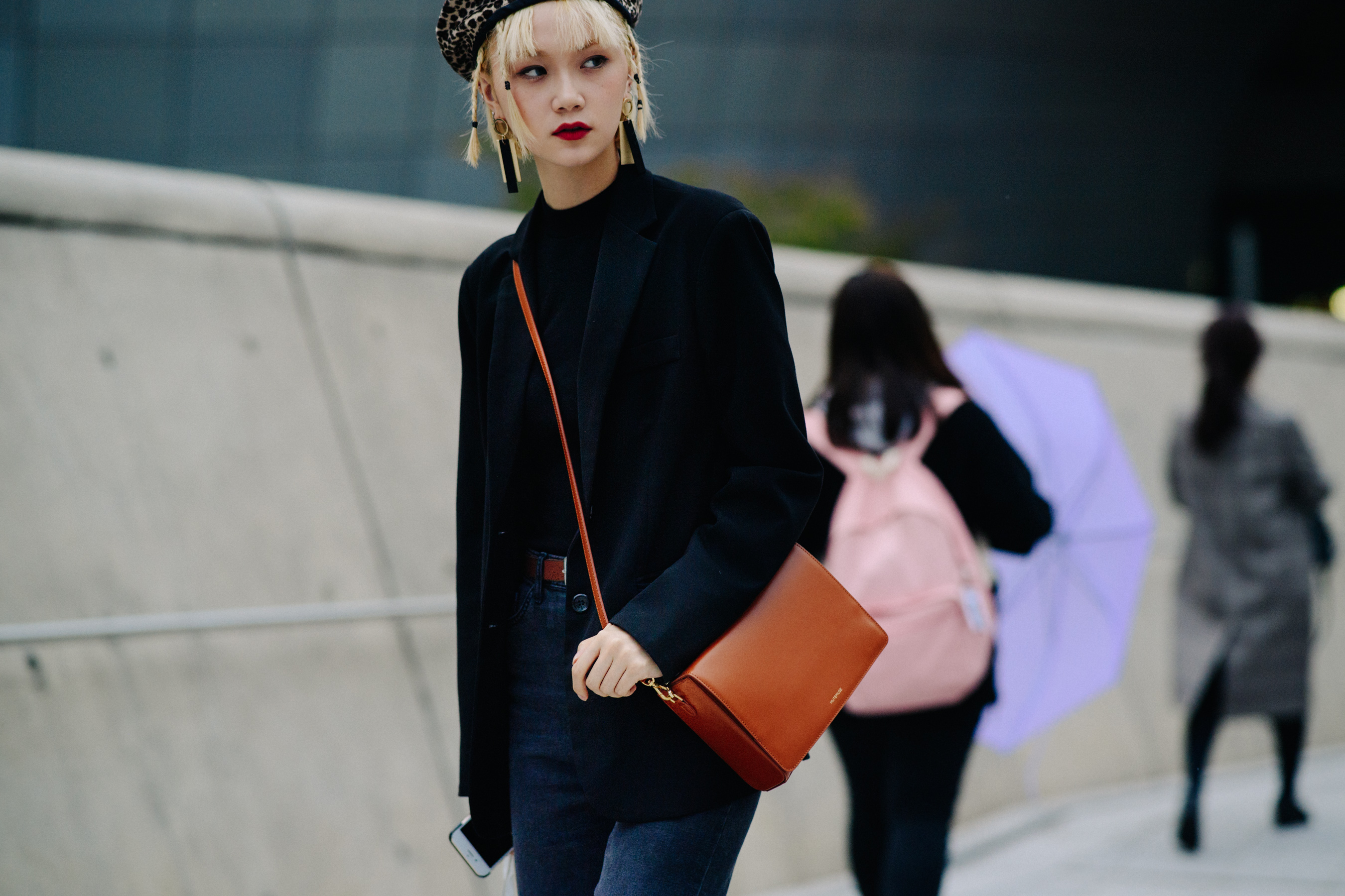 Model wearing dark coat and animal print beret