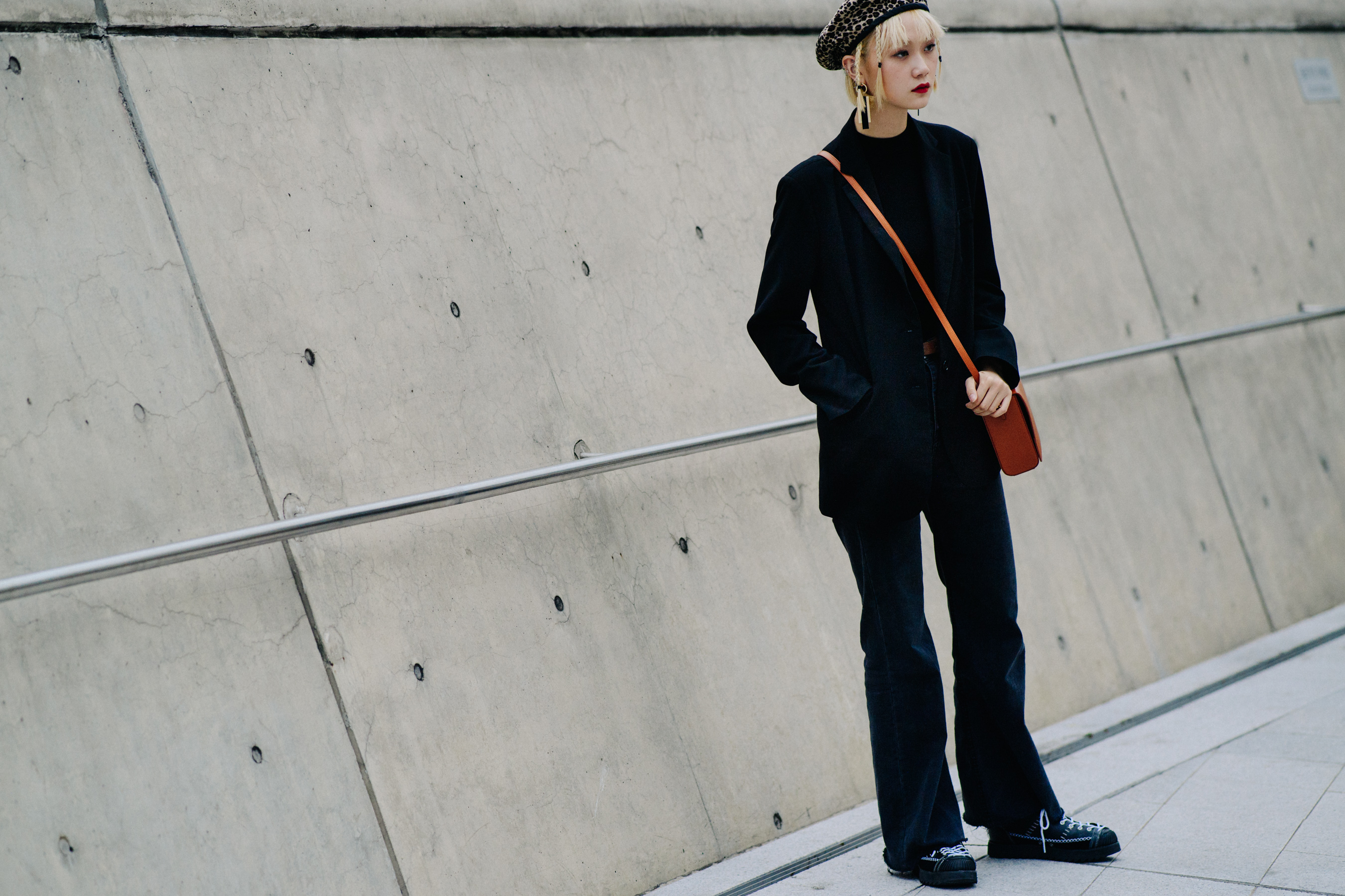 Model wearing dark coat and animal print beret