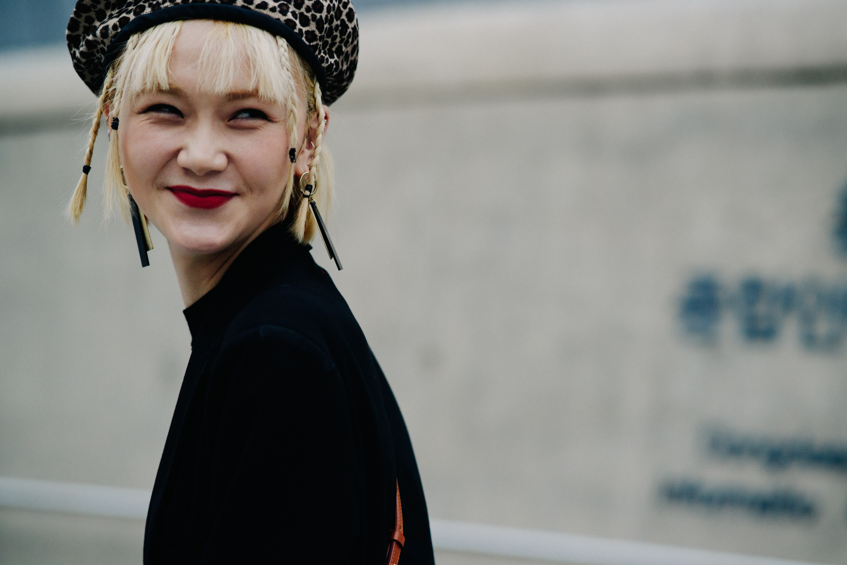 Model wearing dark coat and animal print beret