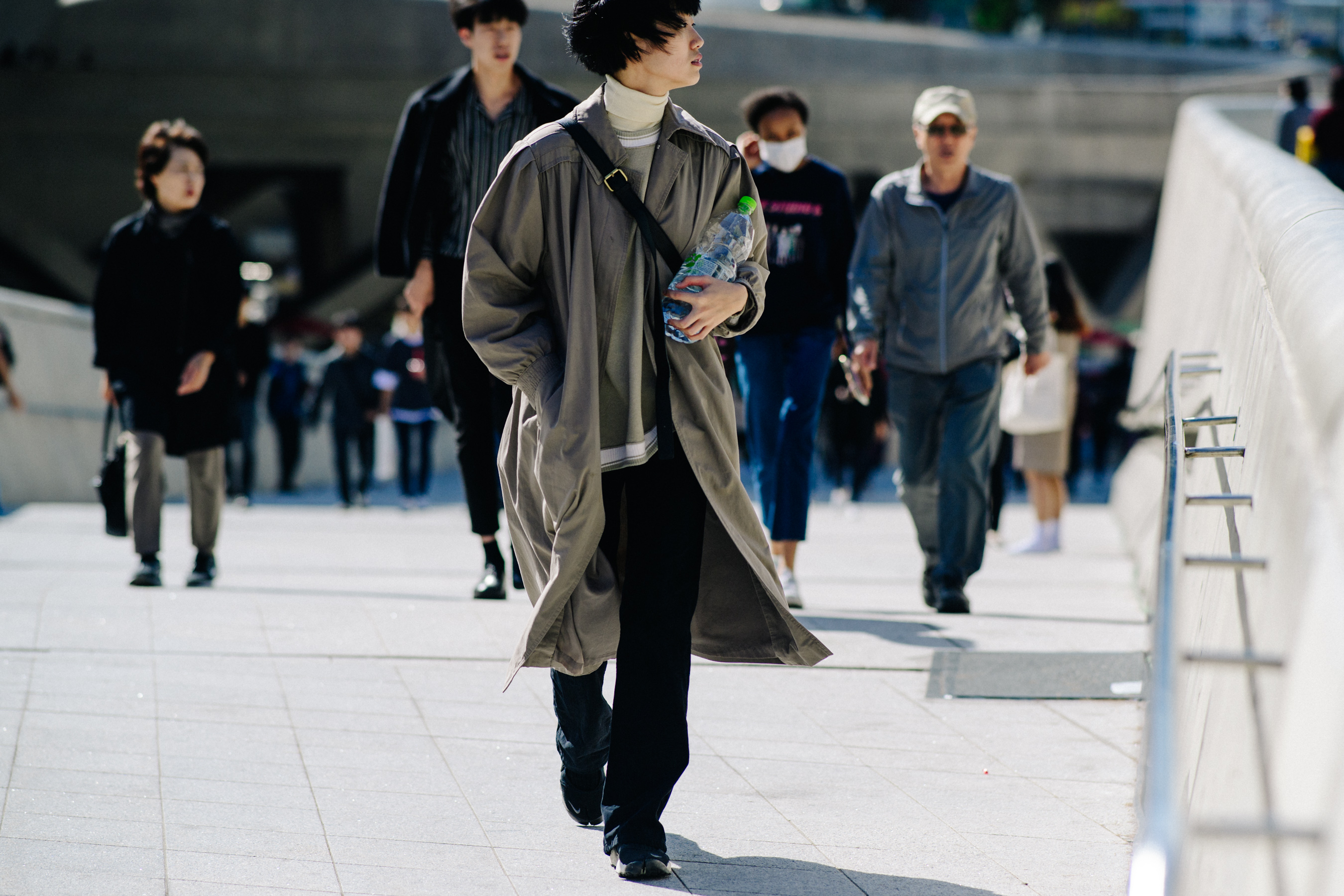 Woman wearing grey overcoat and black trousers