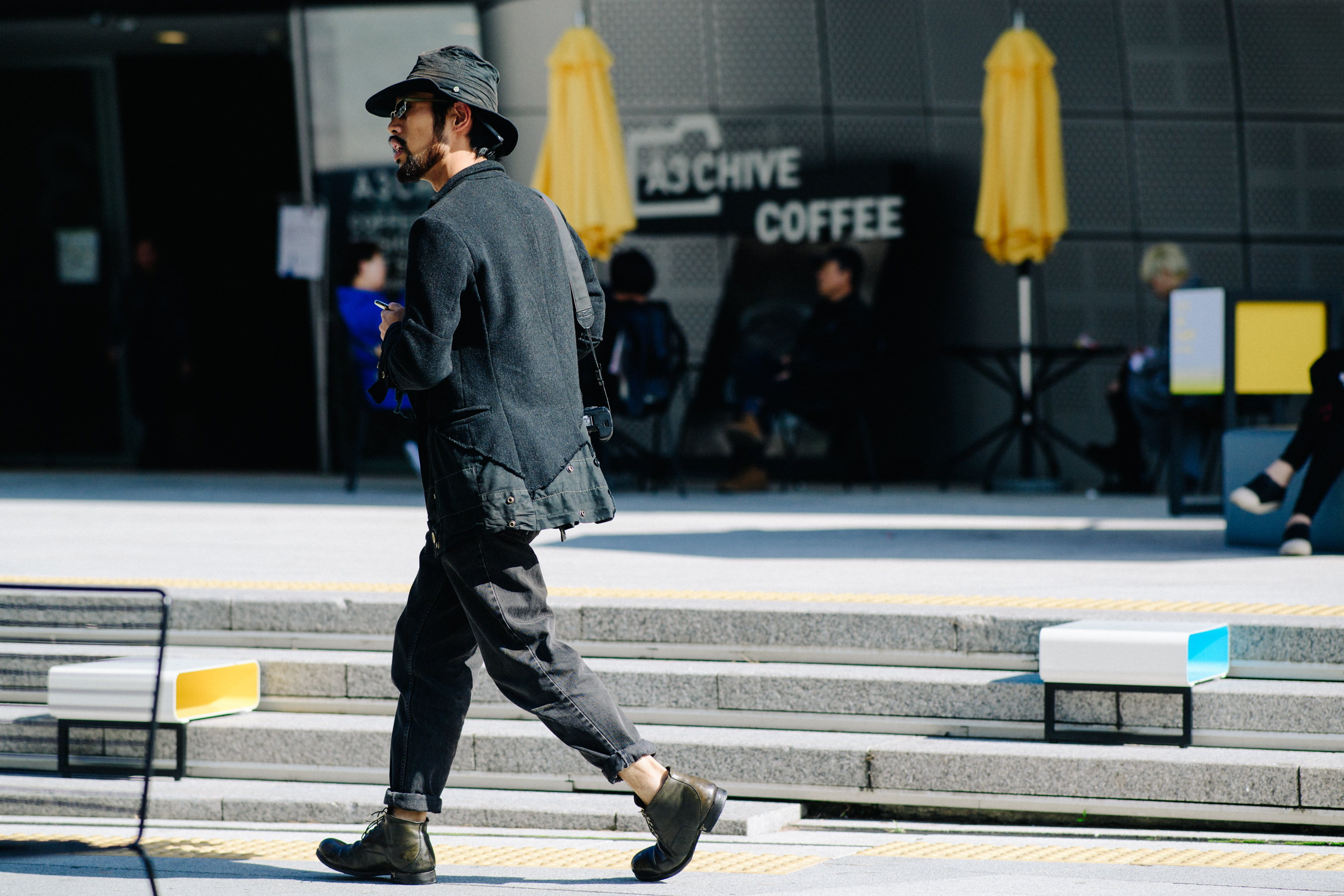 Man walking in dark denim and wool outfit