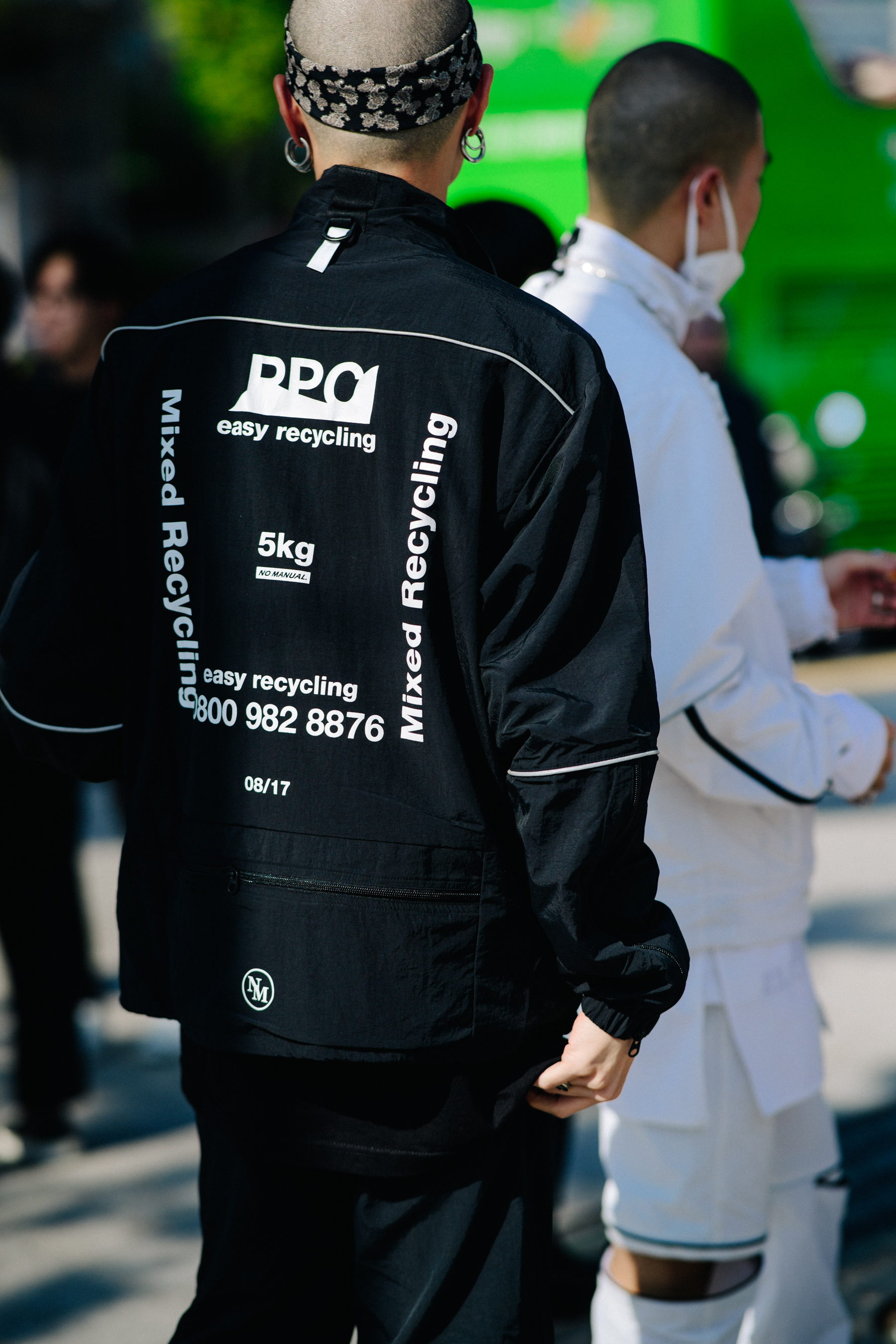 Crop of man in black jacket with white printed words