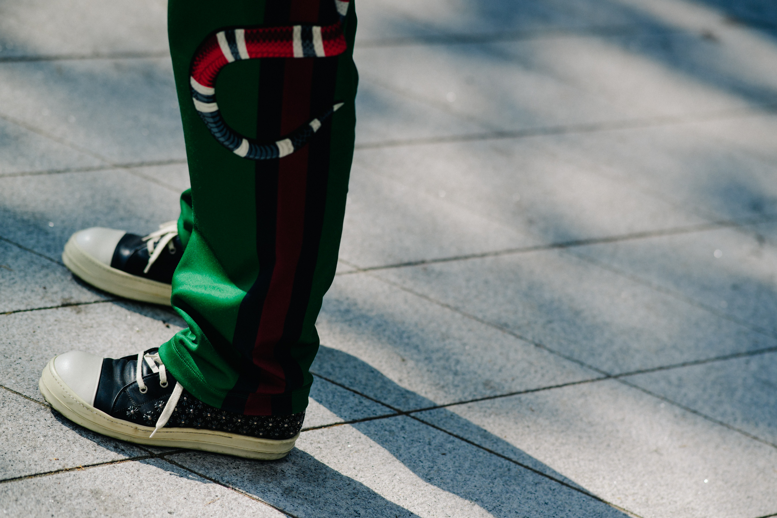 Closeup of Gucci pants with black leather boots