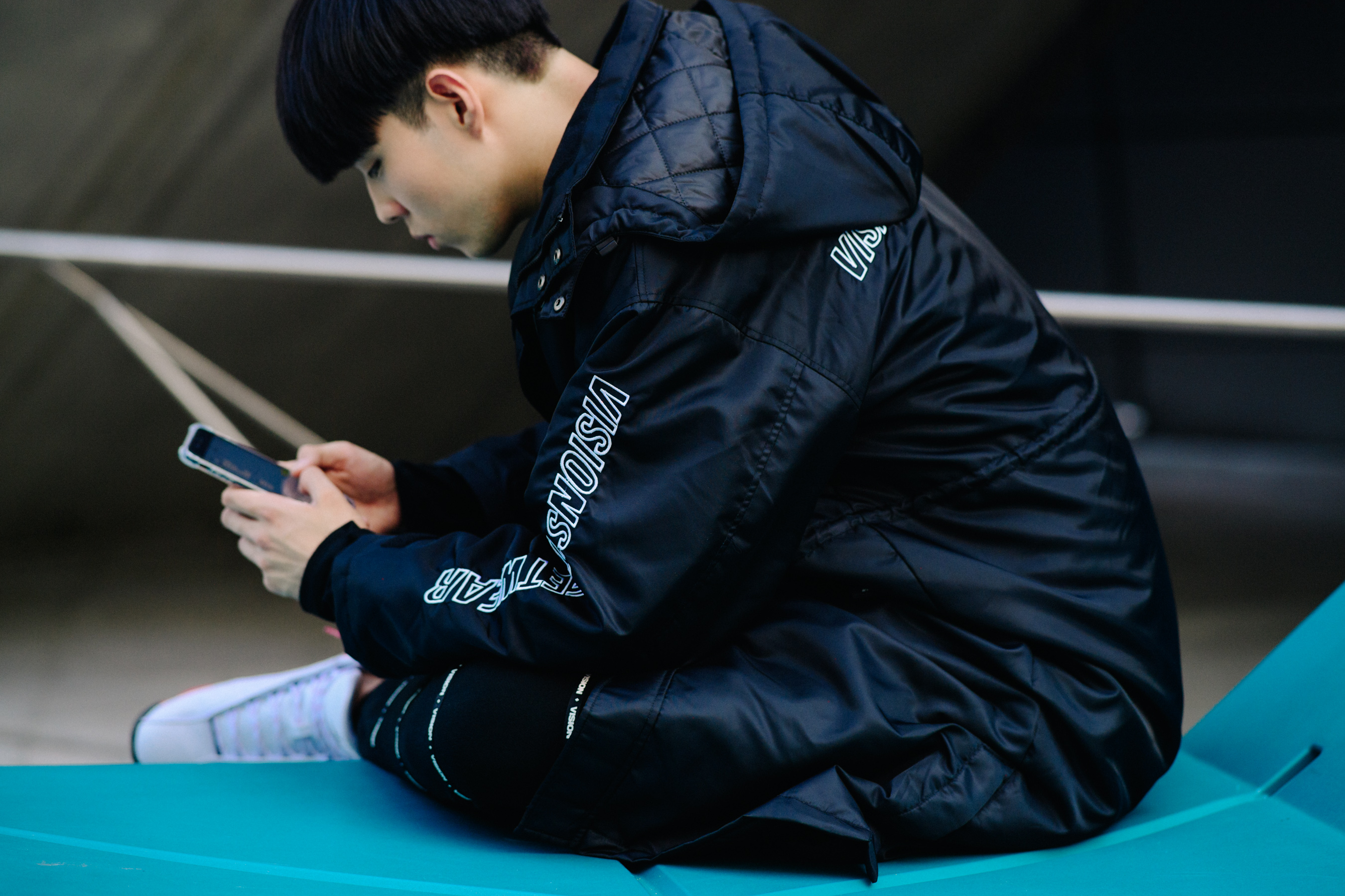 Crop of man in black Vision Streetwear coat
