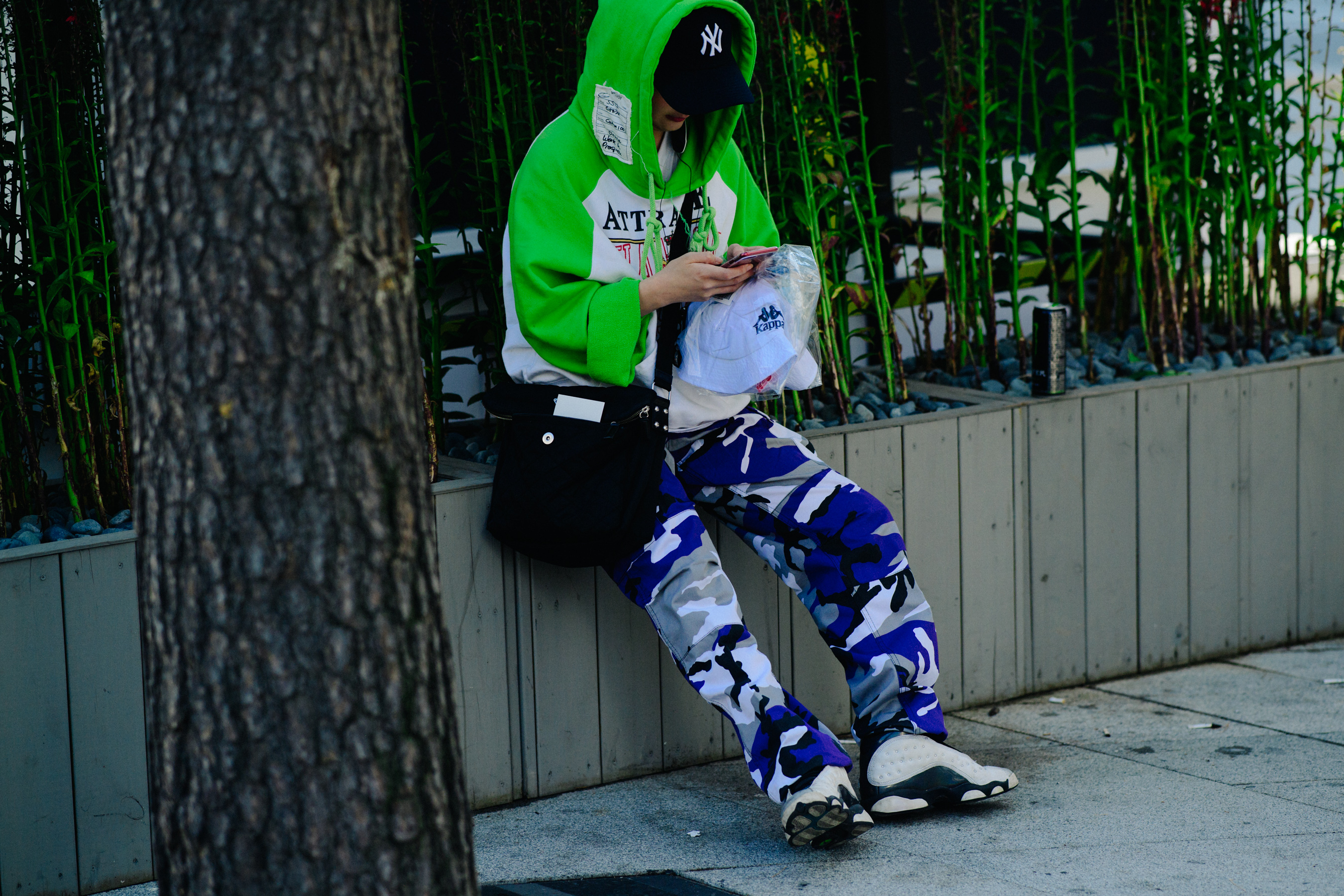 Woman sat down in green hoody with camo pants