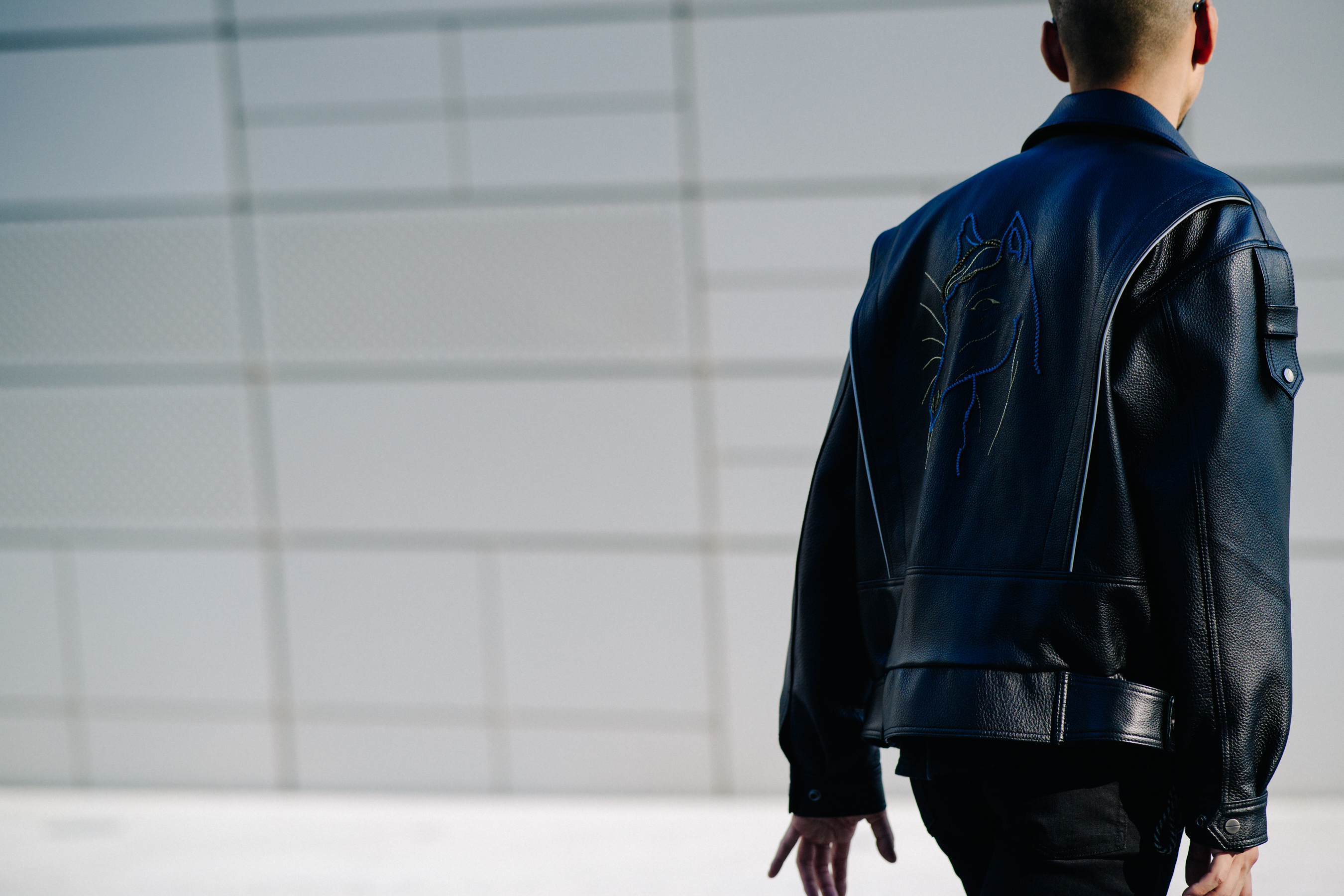 Back of man in black leather jacket