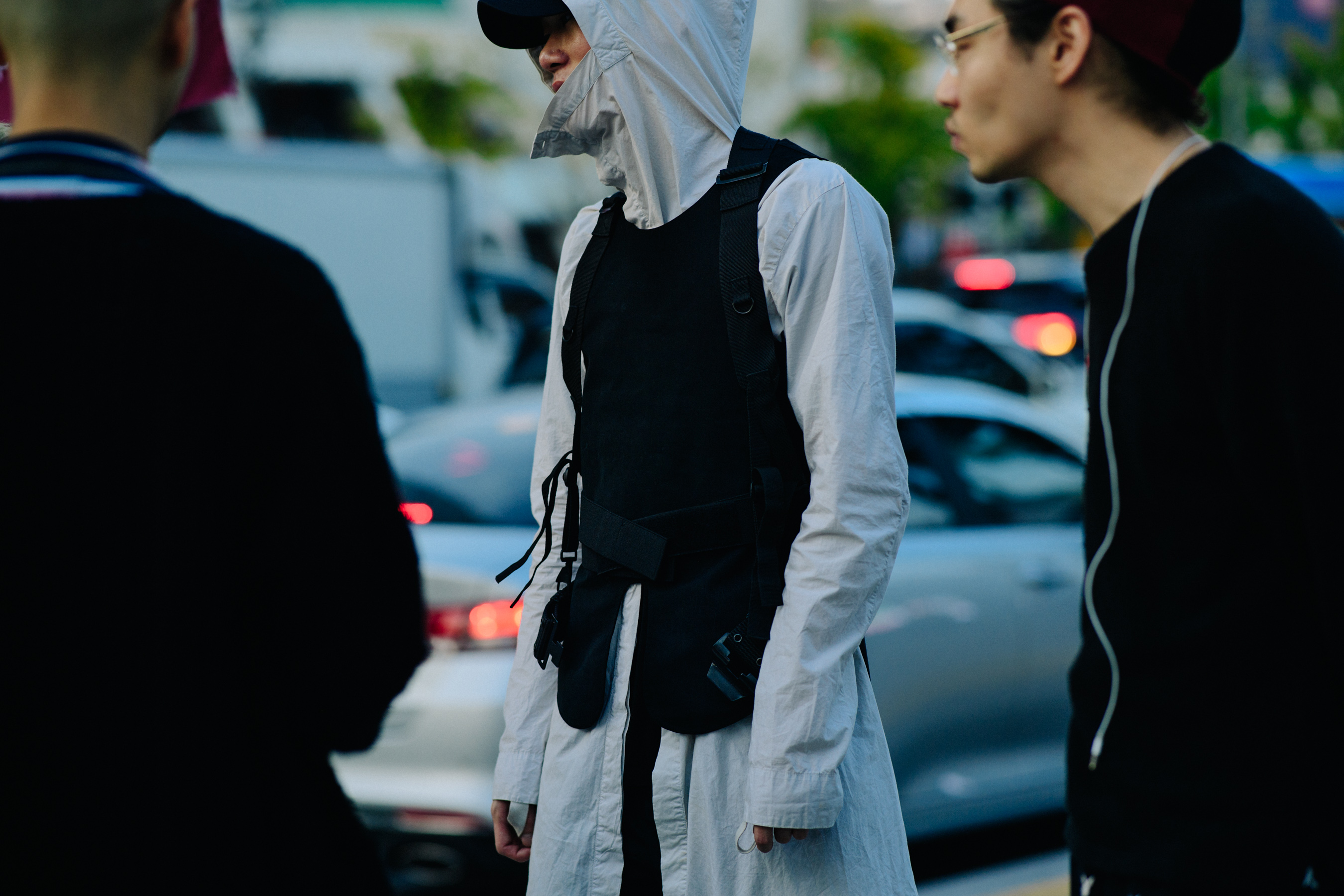 Man wearing grey hooded shirt under black vest