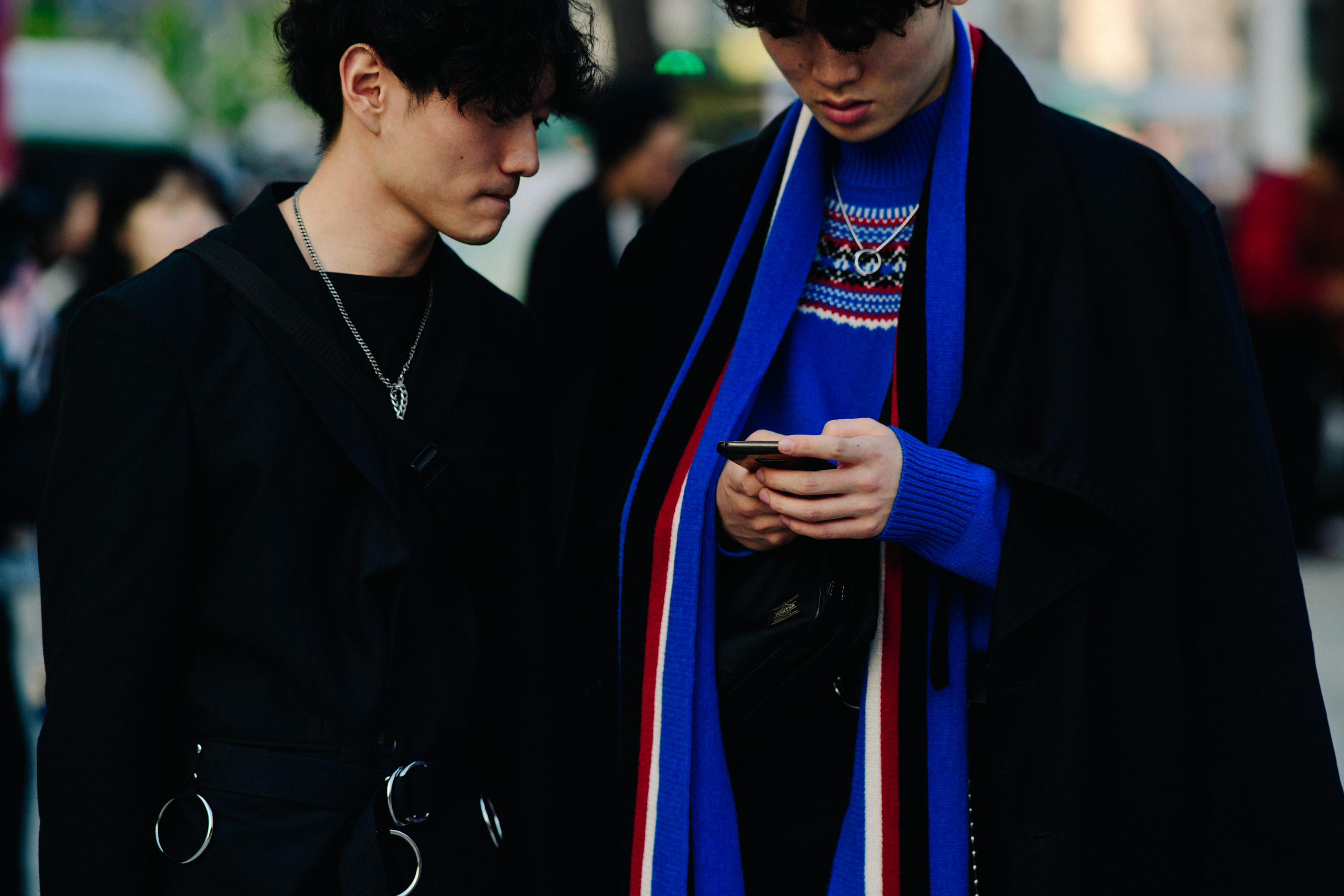 Two men in dark coats with silver jewellery