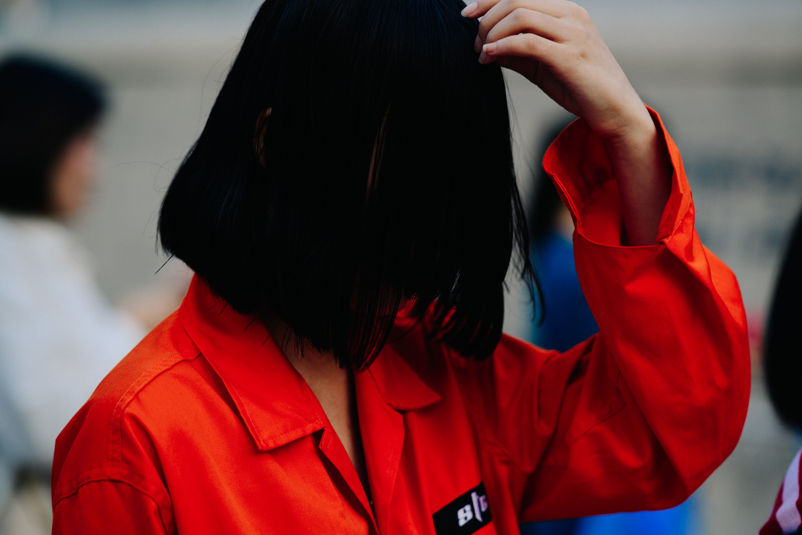 Closeup of woman adjusting hair in red shirt