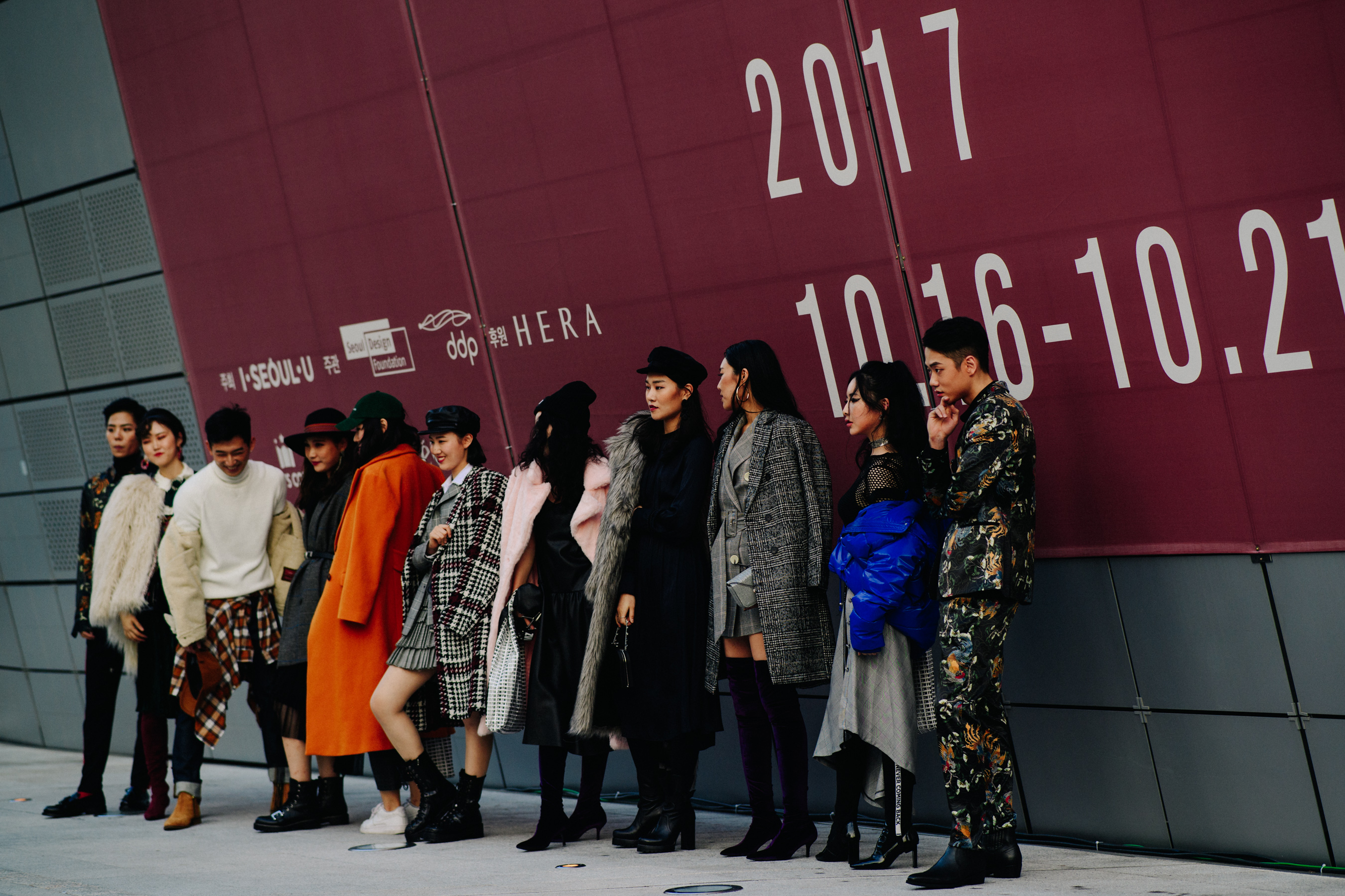 Group of people posing by large sign