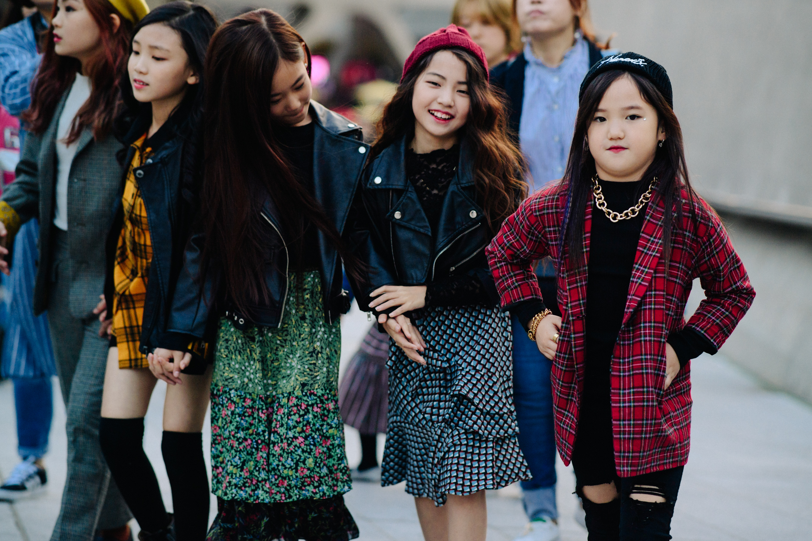Four children wearing colourful skirts and shirts