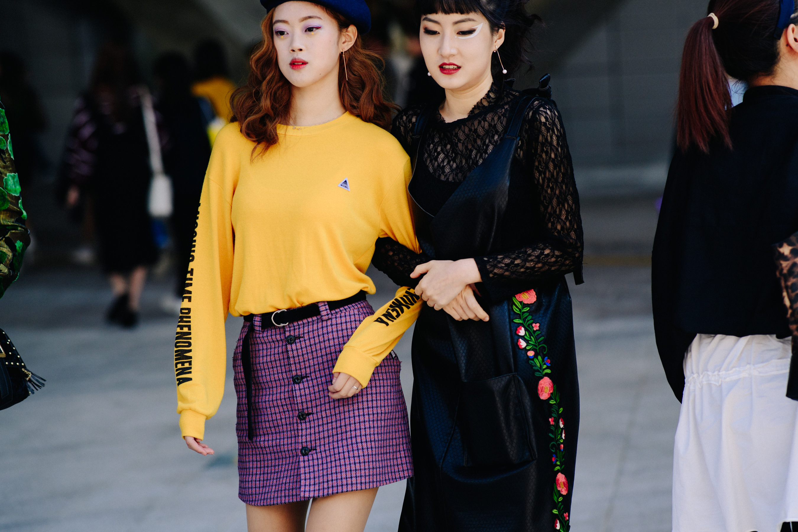 Two women linking arms in colourful patterns