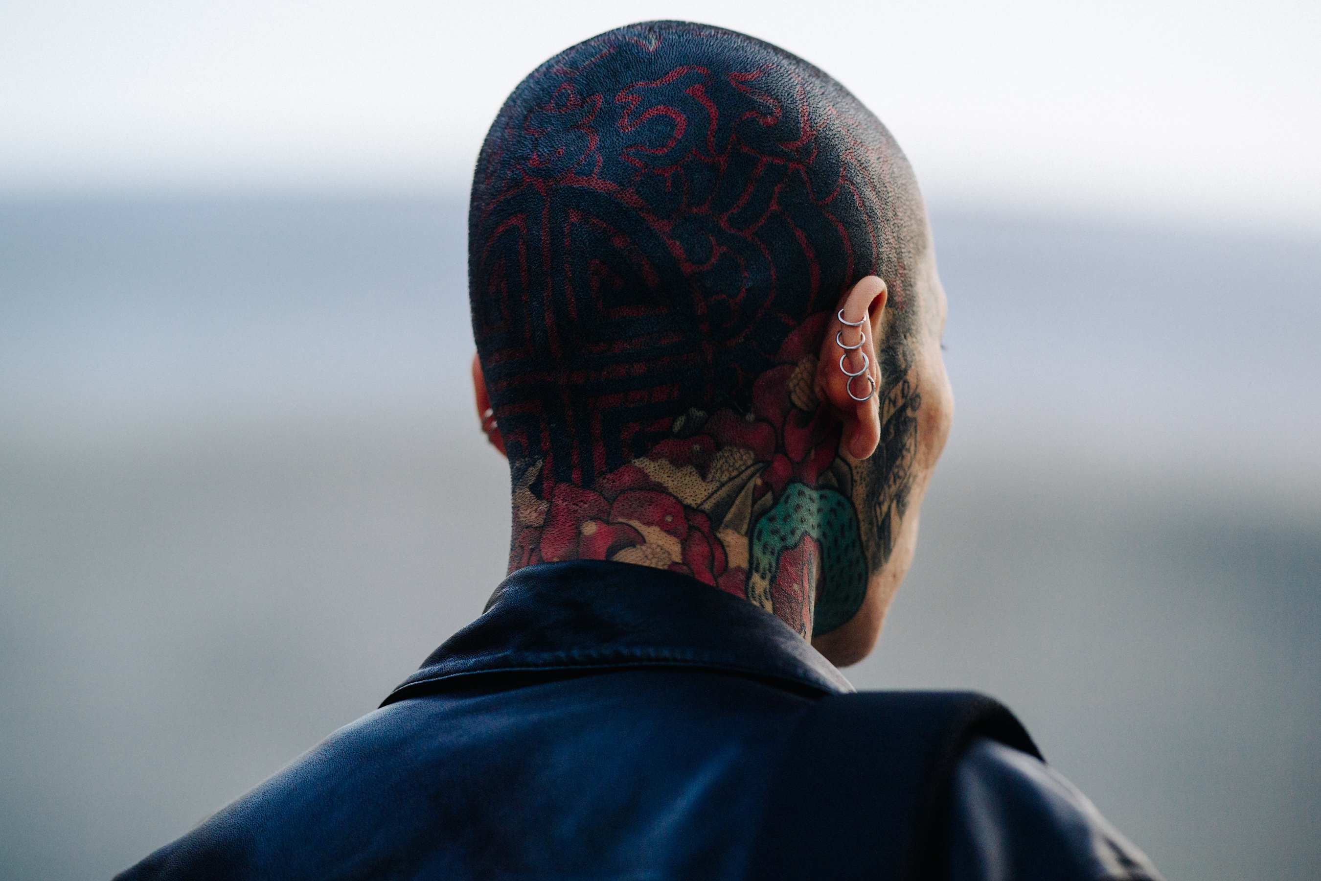 Back of mans tattooed head with earrings