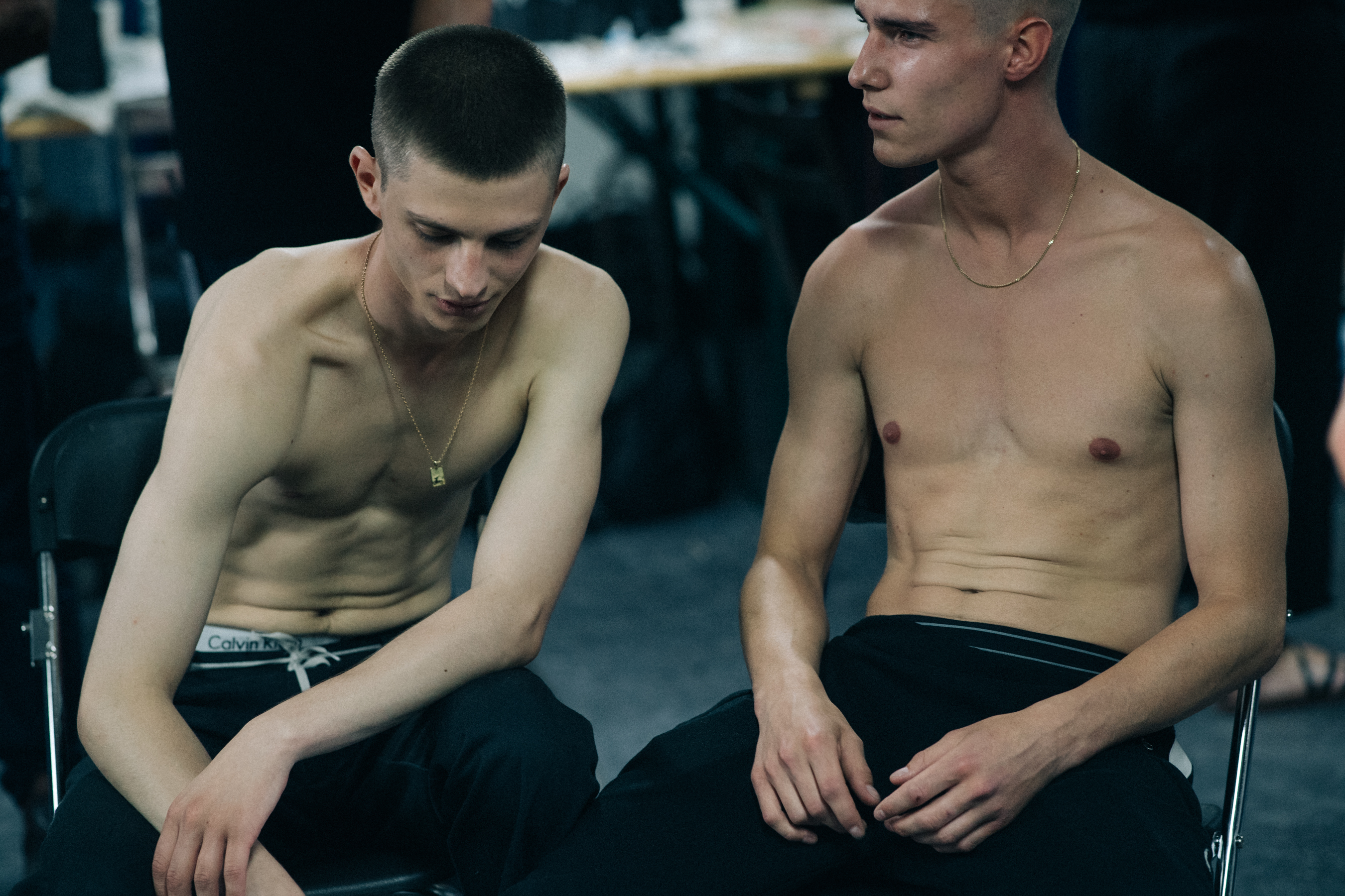Two models sat down without tops on