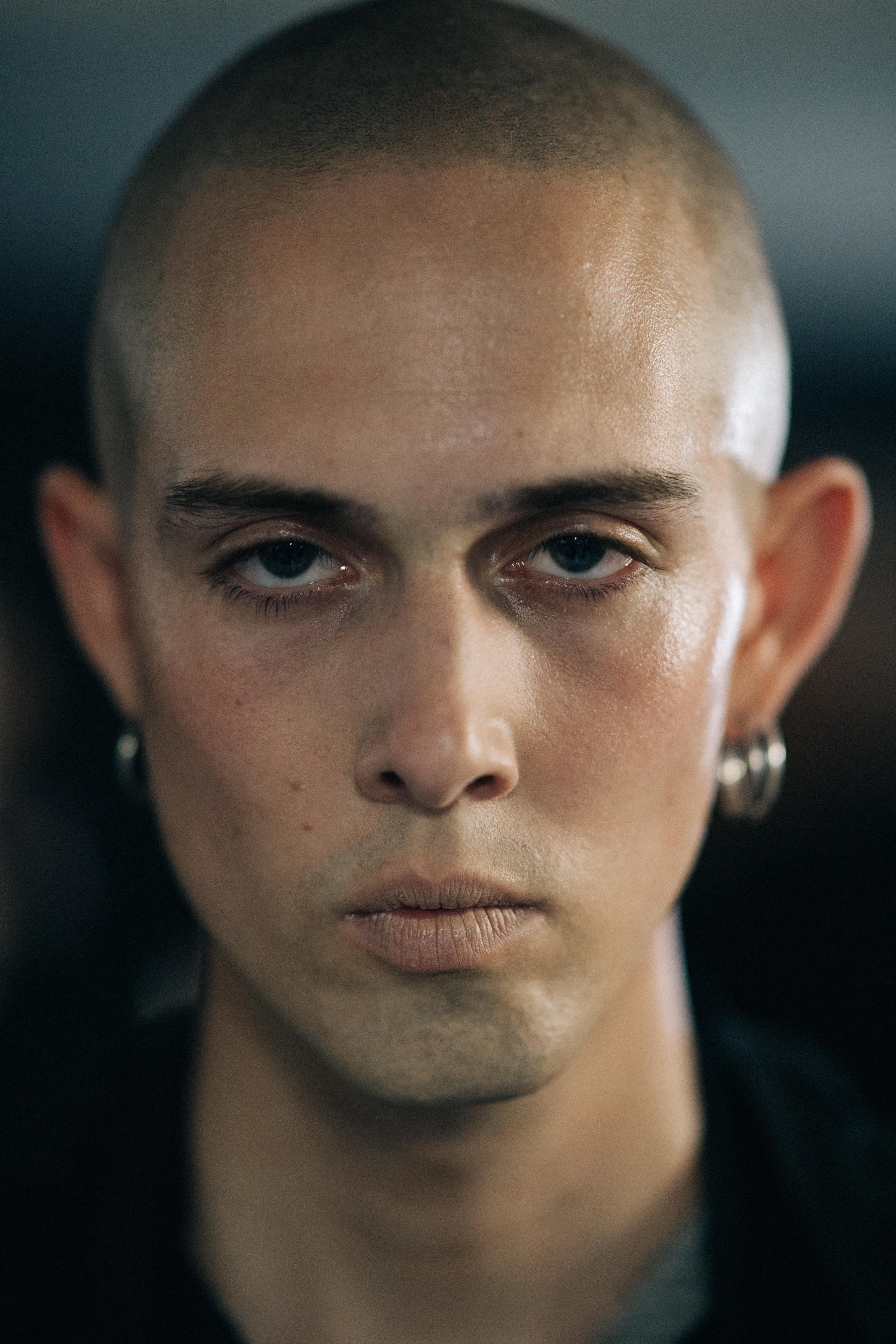 Portrait of model with shaved head and earrings