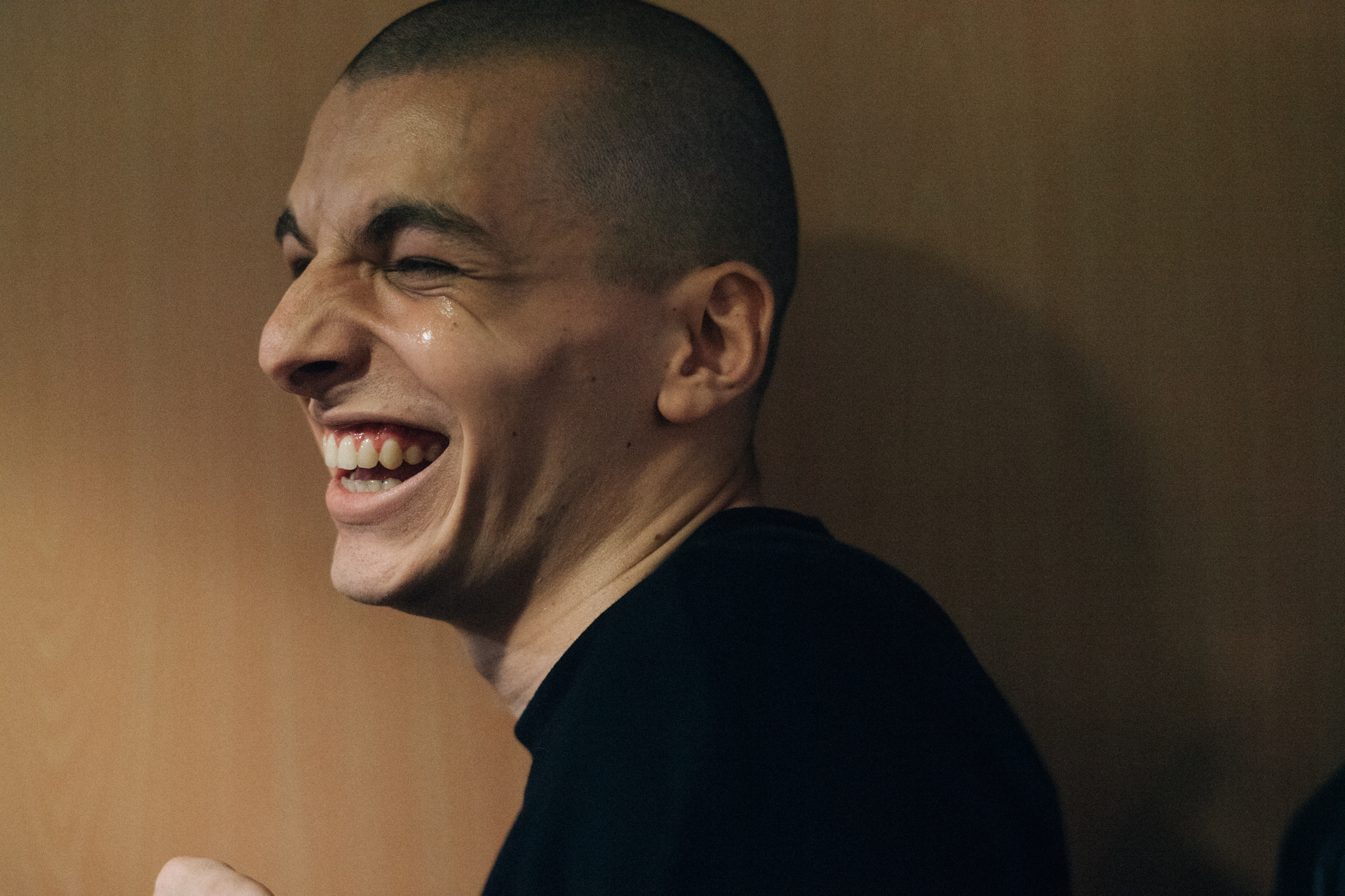 Model laughing with shaved head