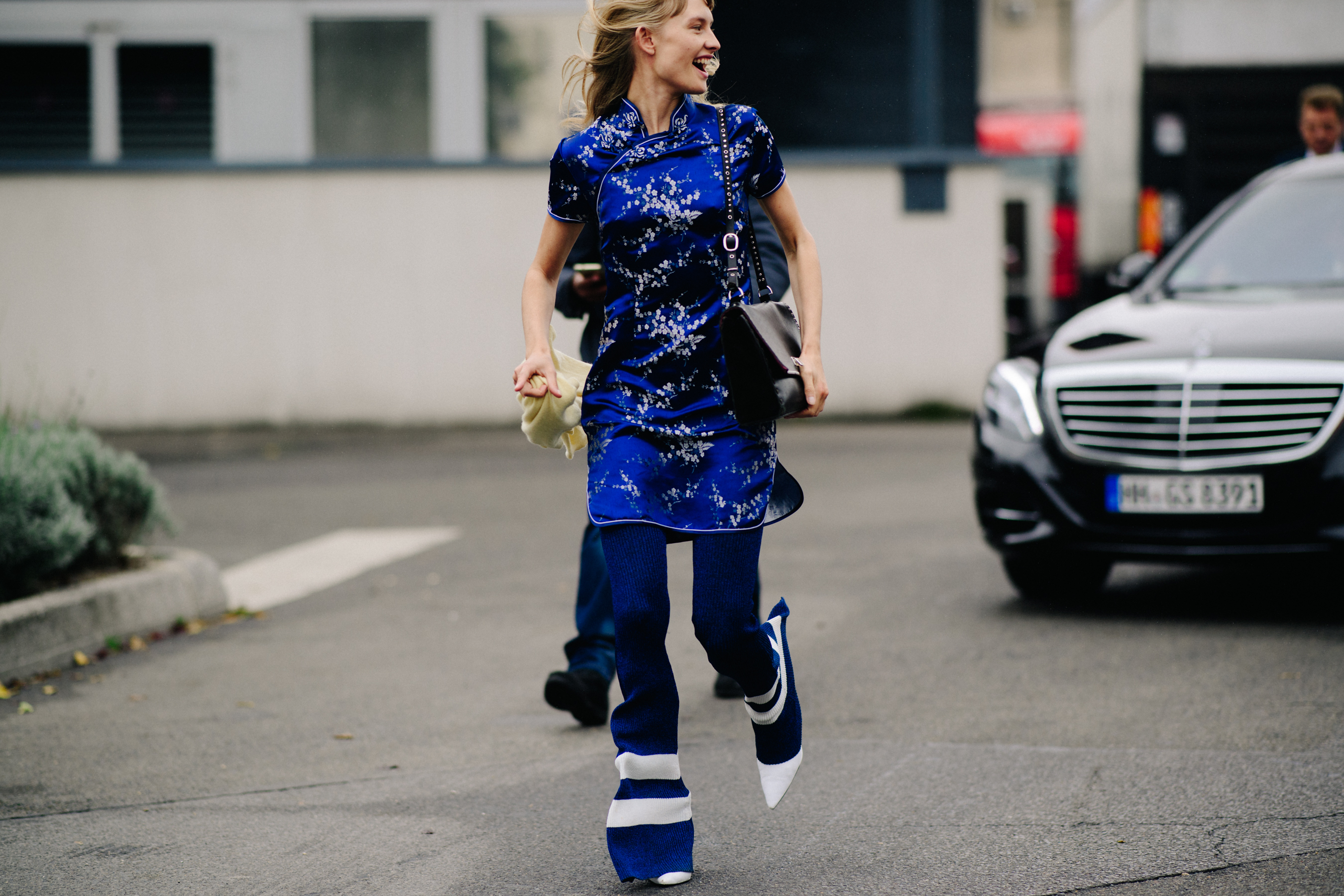 Model wearing blue outfit after a show