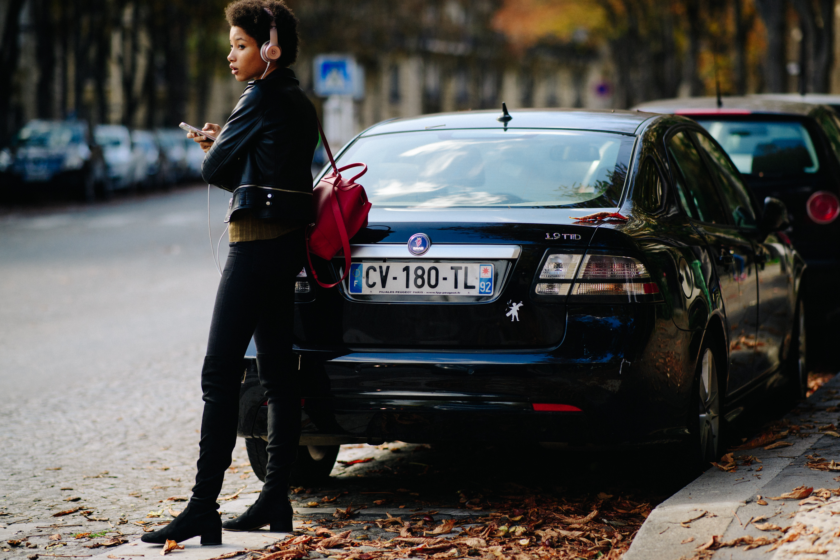 Model wearing black boots and red backpack