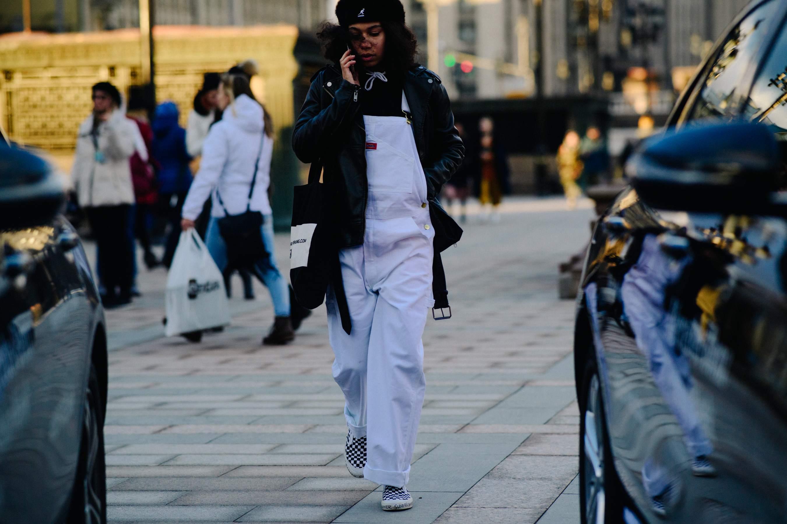 Woman on phone in white dungarees