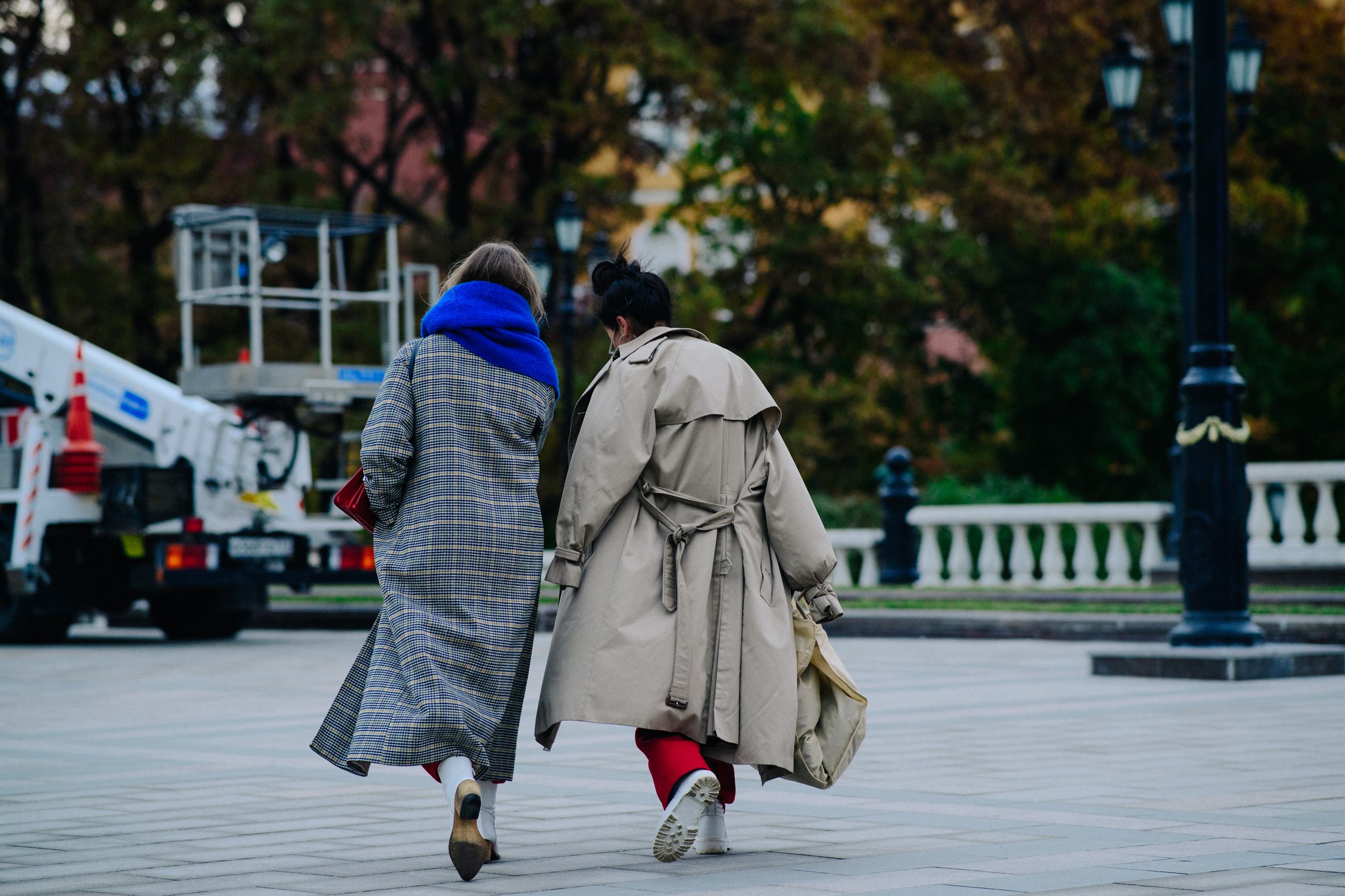 Two women wearing long formal winter coats
