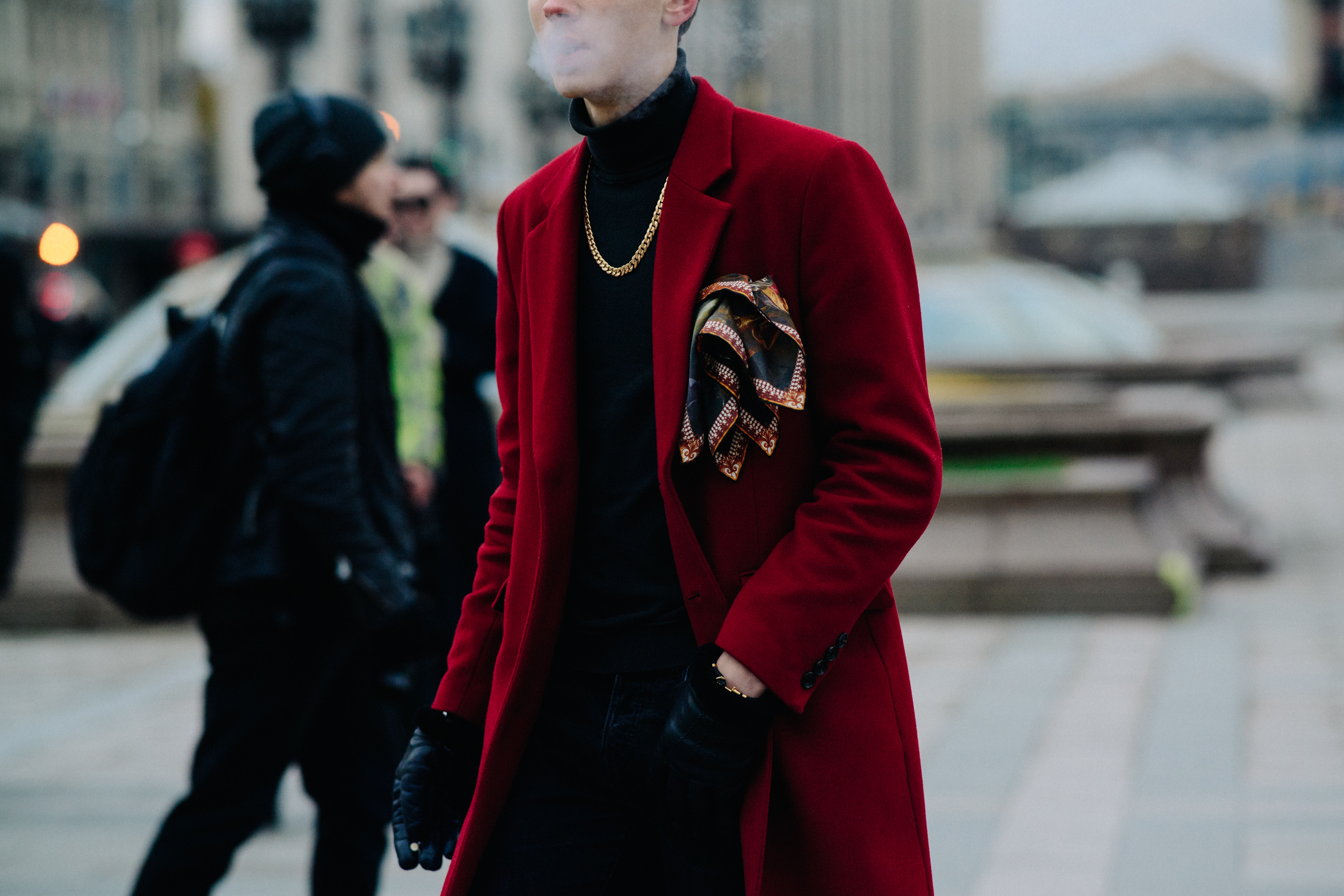 Man smoking in red coat with gold chain