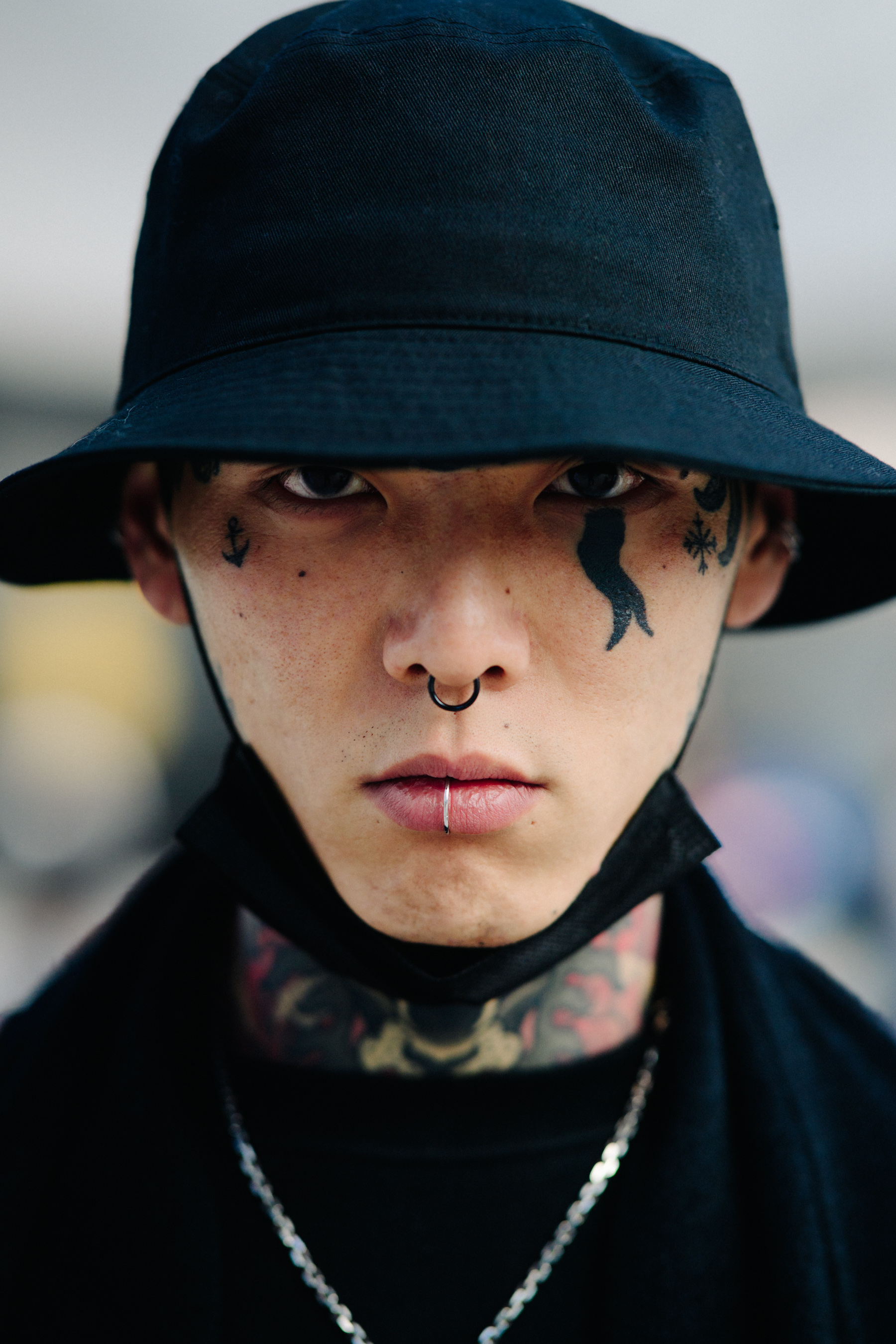 Portrait of model with black bucket hat and face tattoos