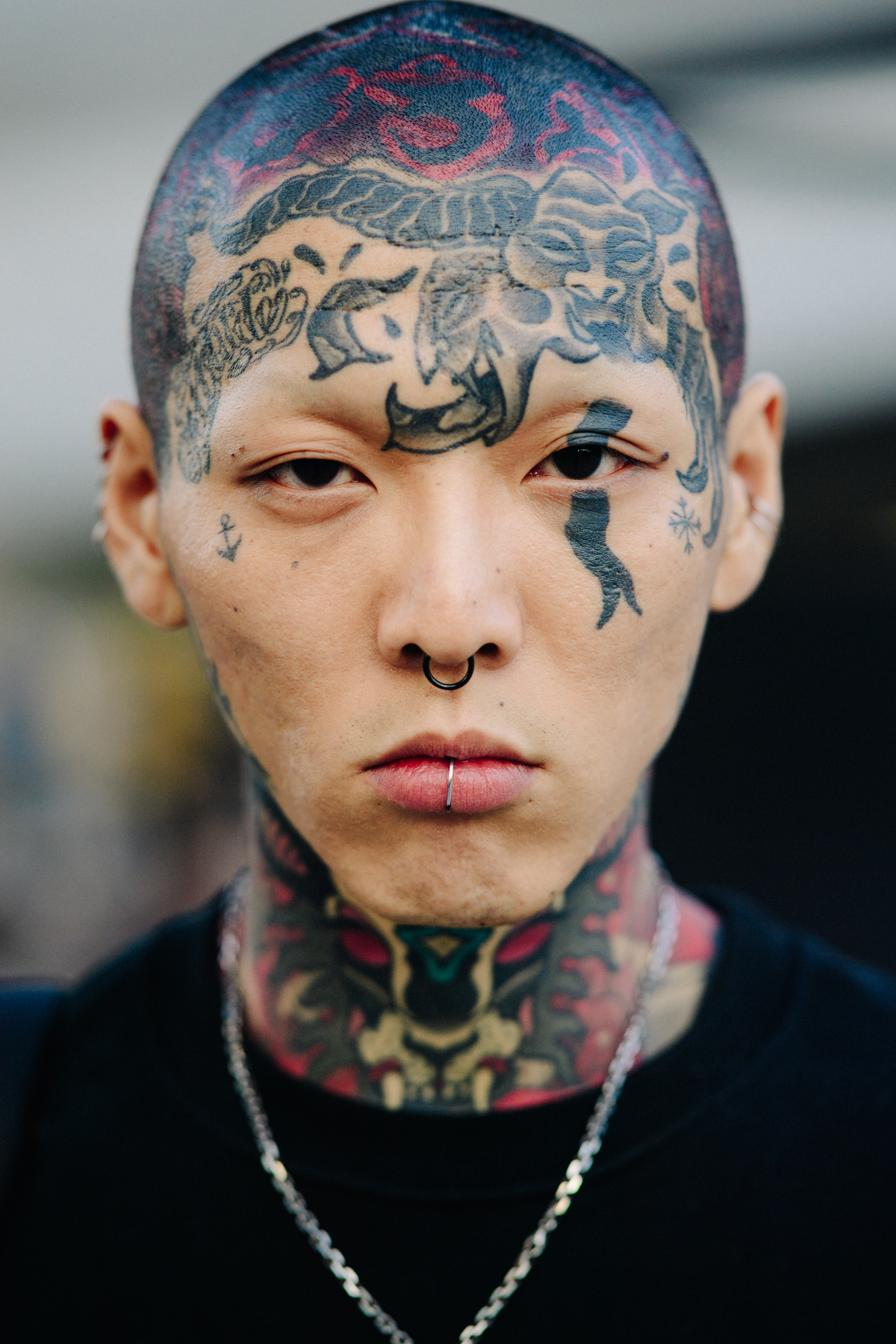 Portrait of Asian man with heavily tattooed face