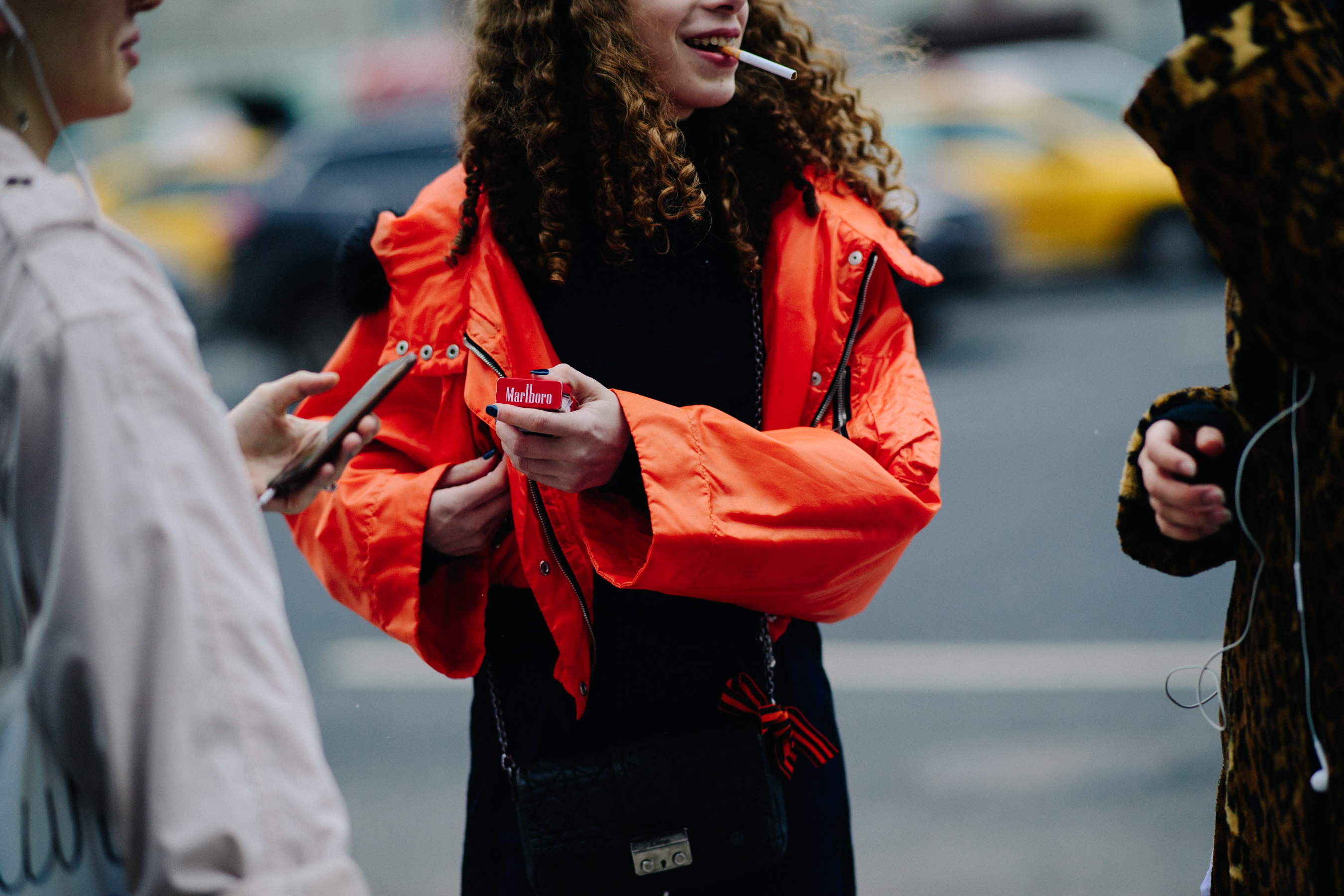 Woman in orange jacket smoking