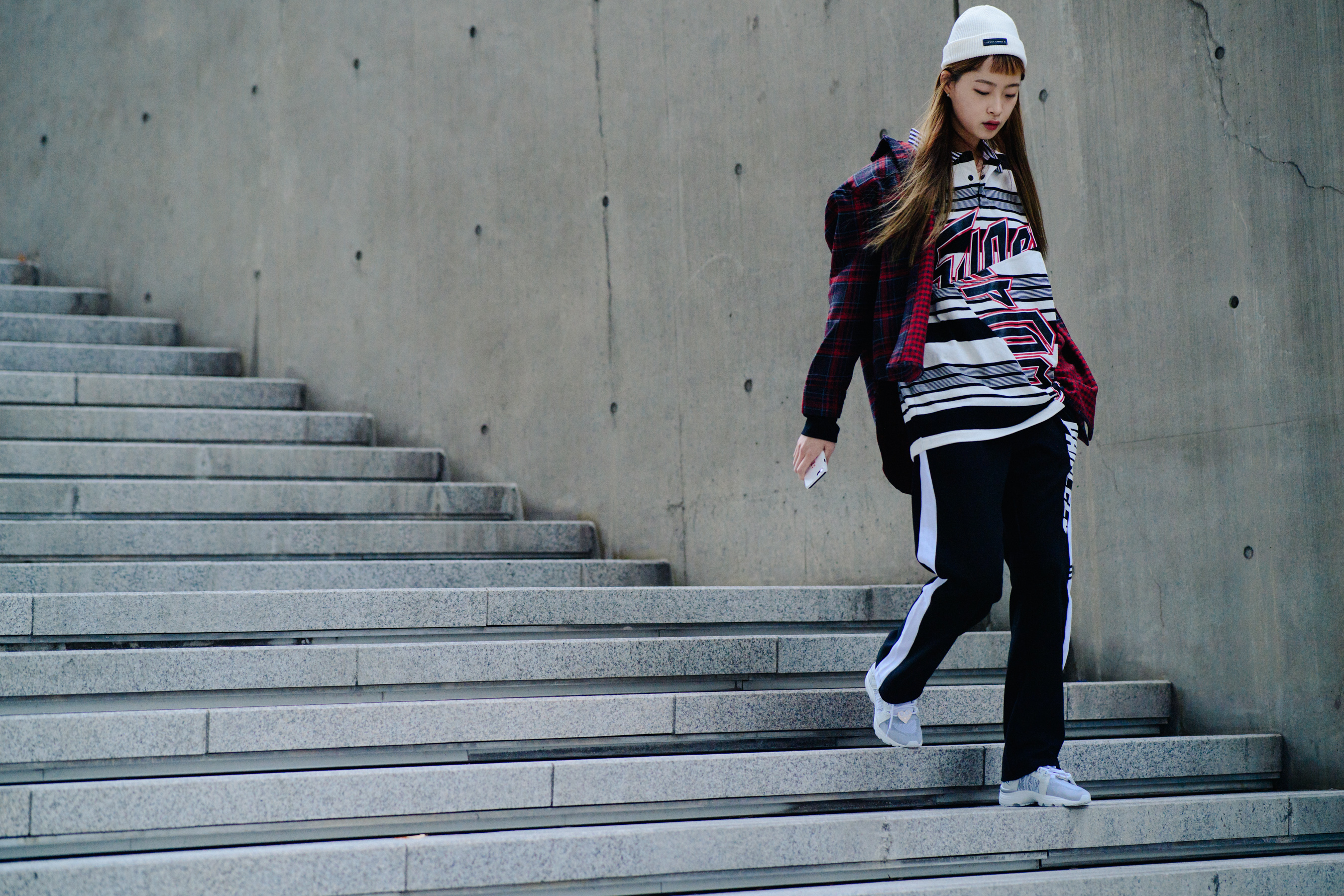 Model walking down stairs in black track pants