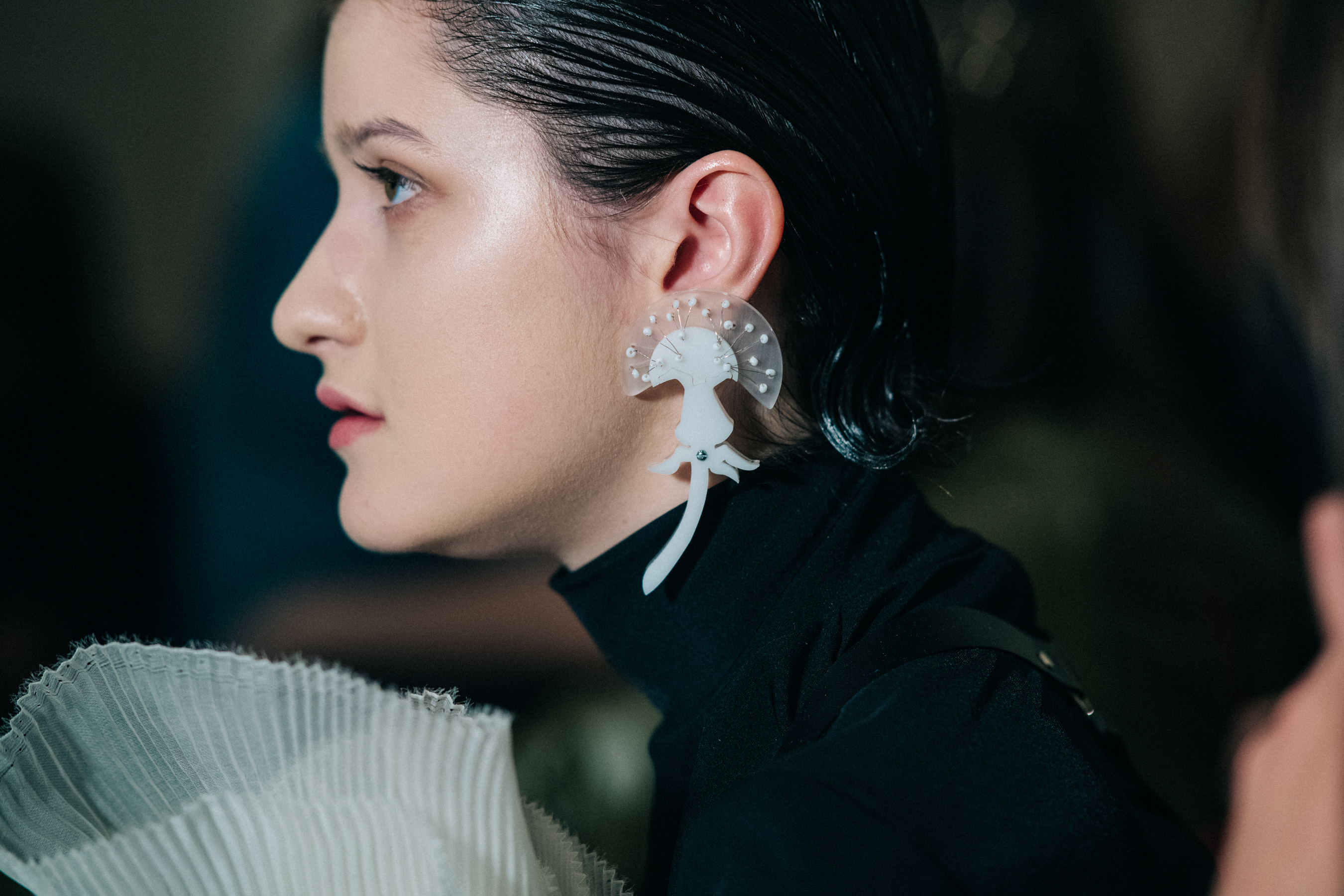 Model wearing white earrings backstage