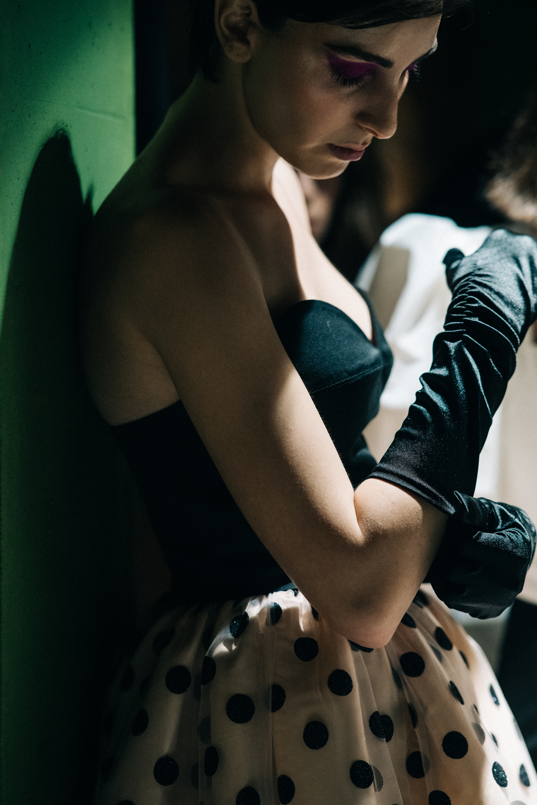 Model backstage in white spotted skirt