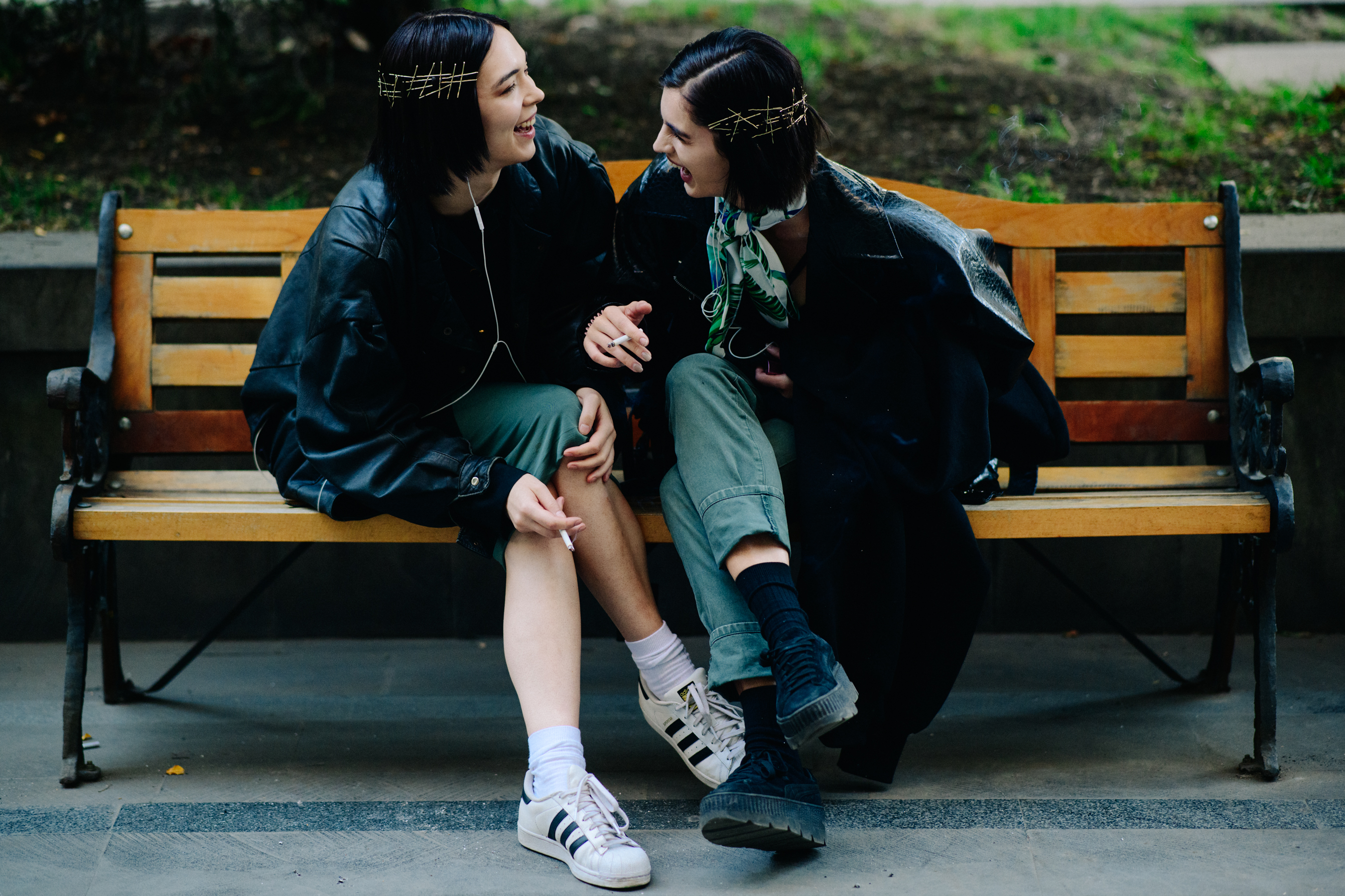 Two models laughing on bench