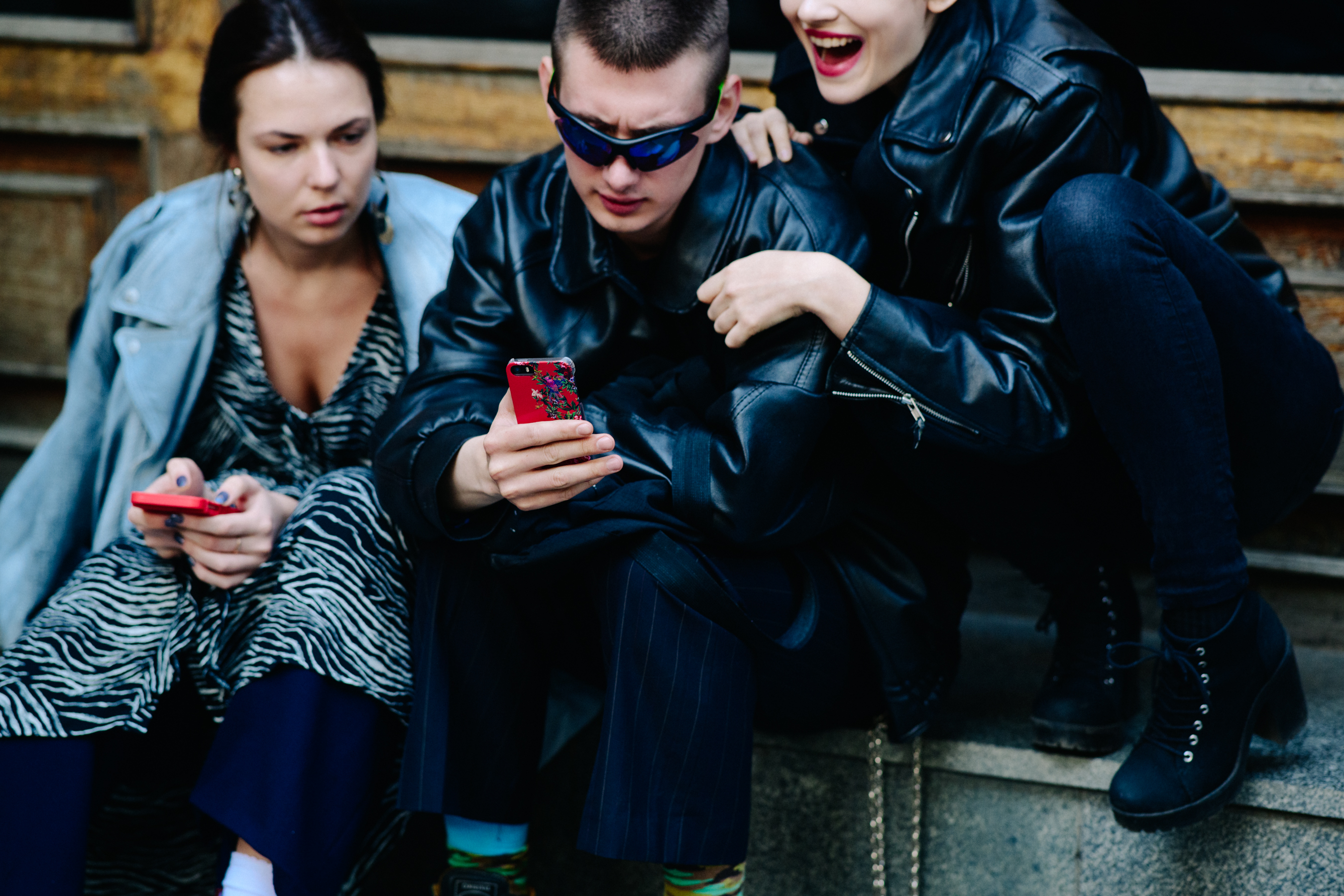 Three people in dark outfits