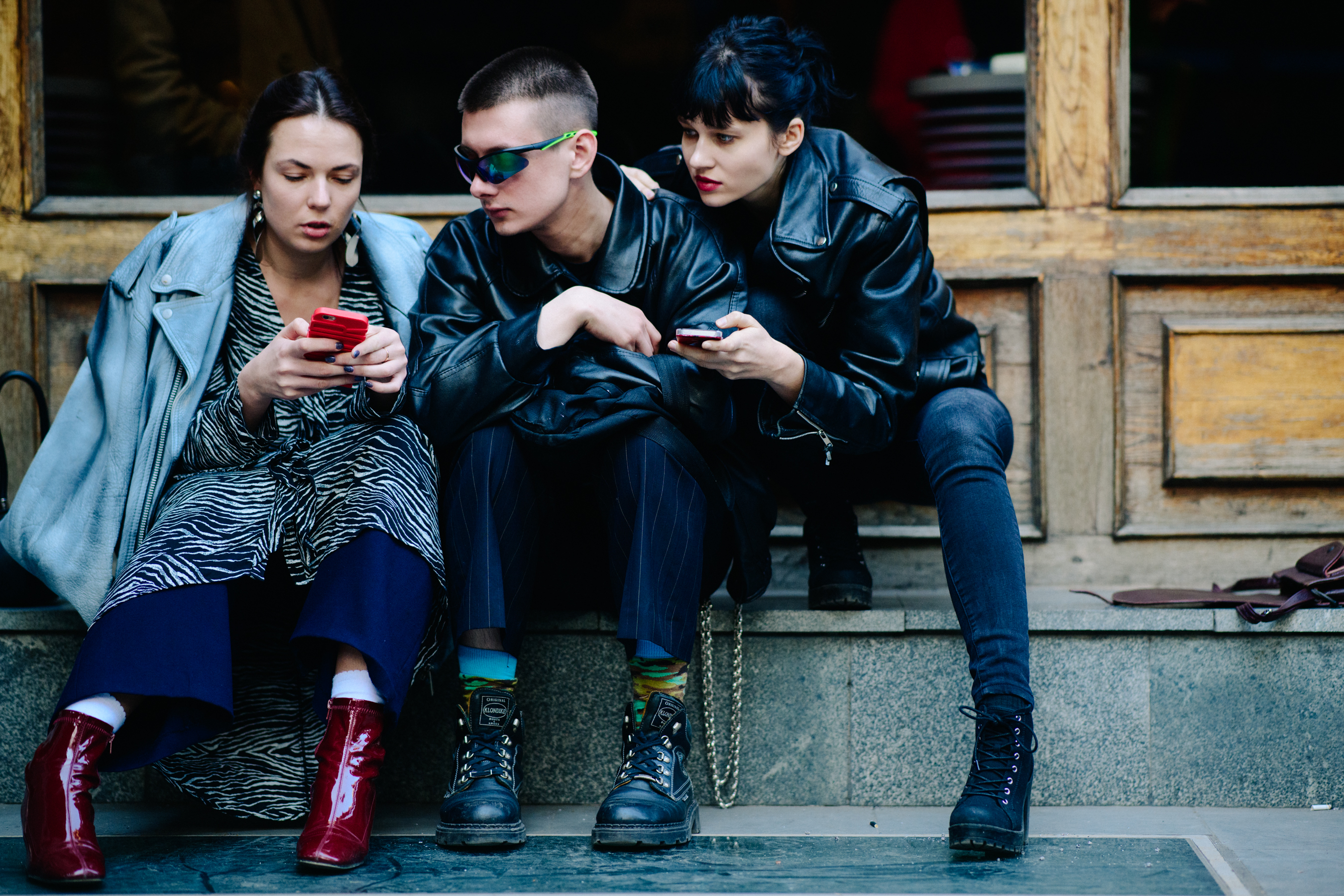 Three people in dark outfits