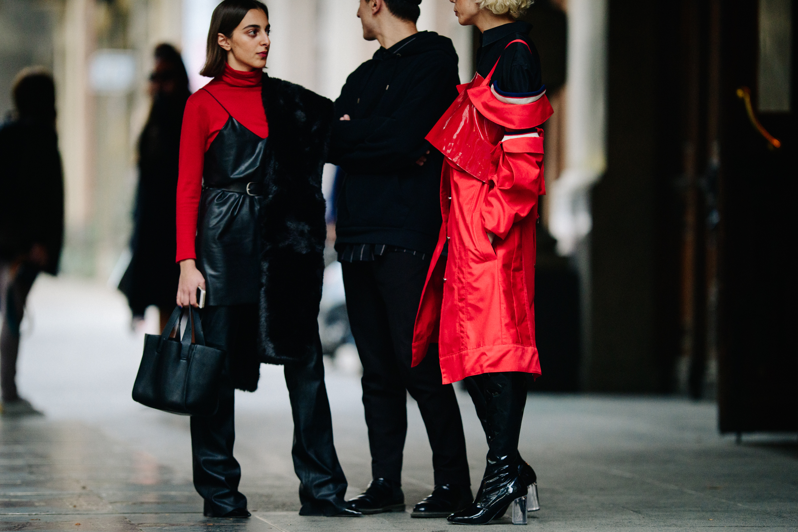 Three people wearing black and red outfits