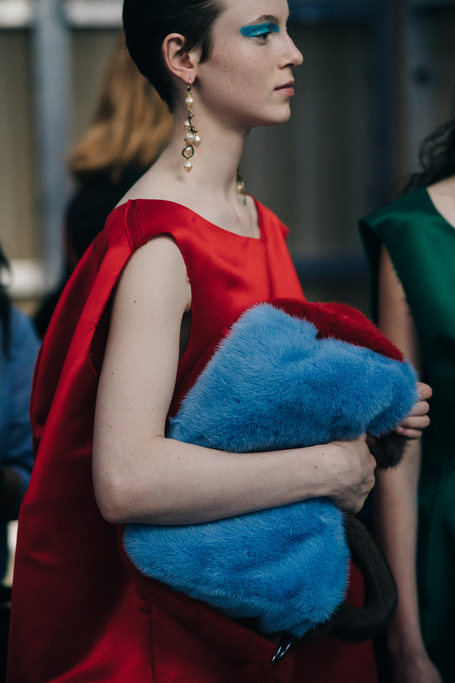 Model holding blue fur bag