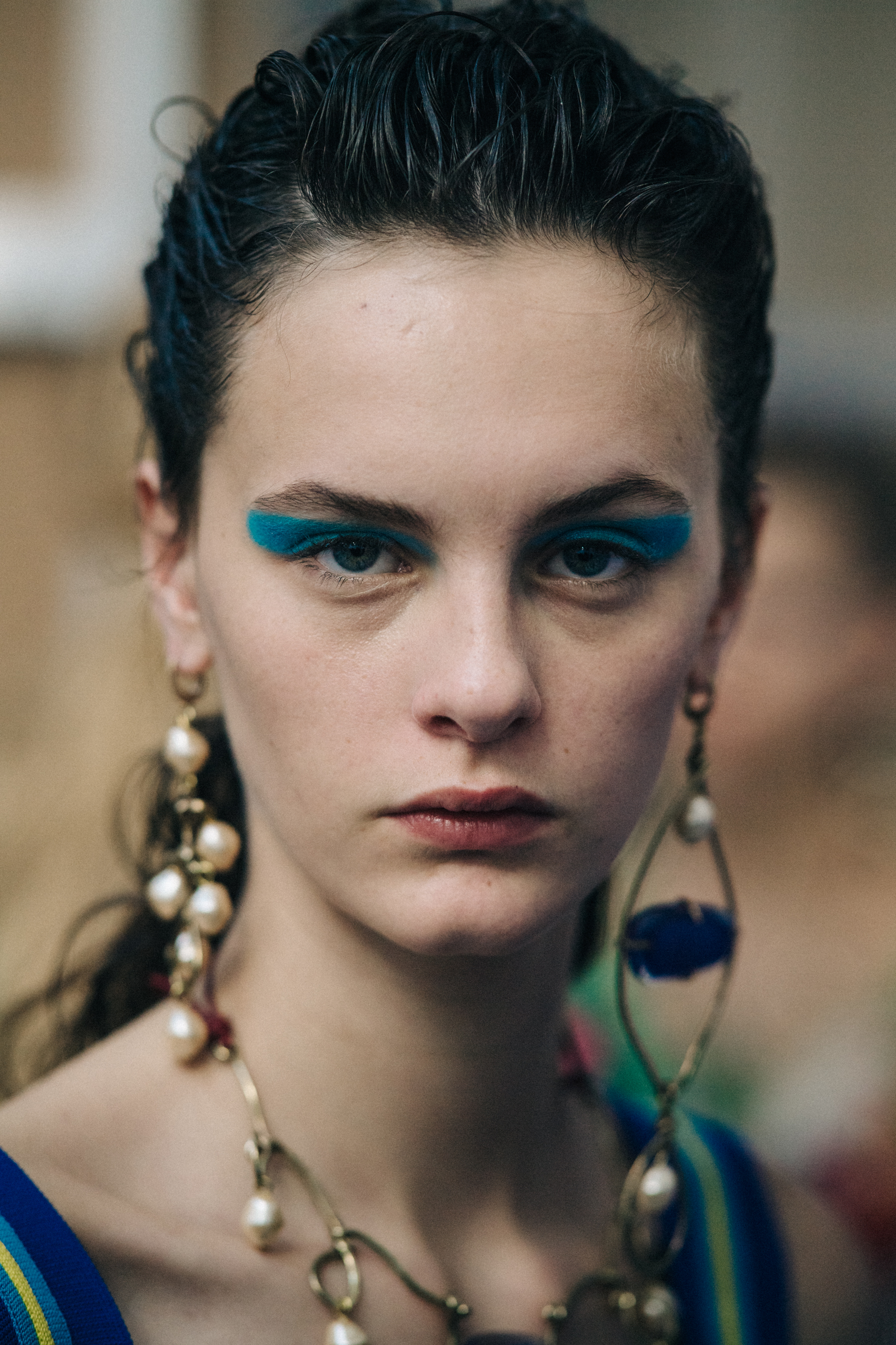 Portrait of model backstage wearing gold earrings
