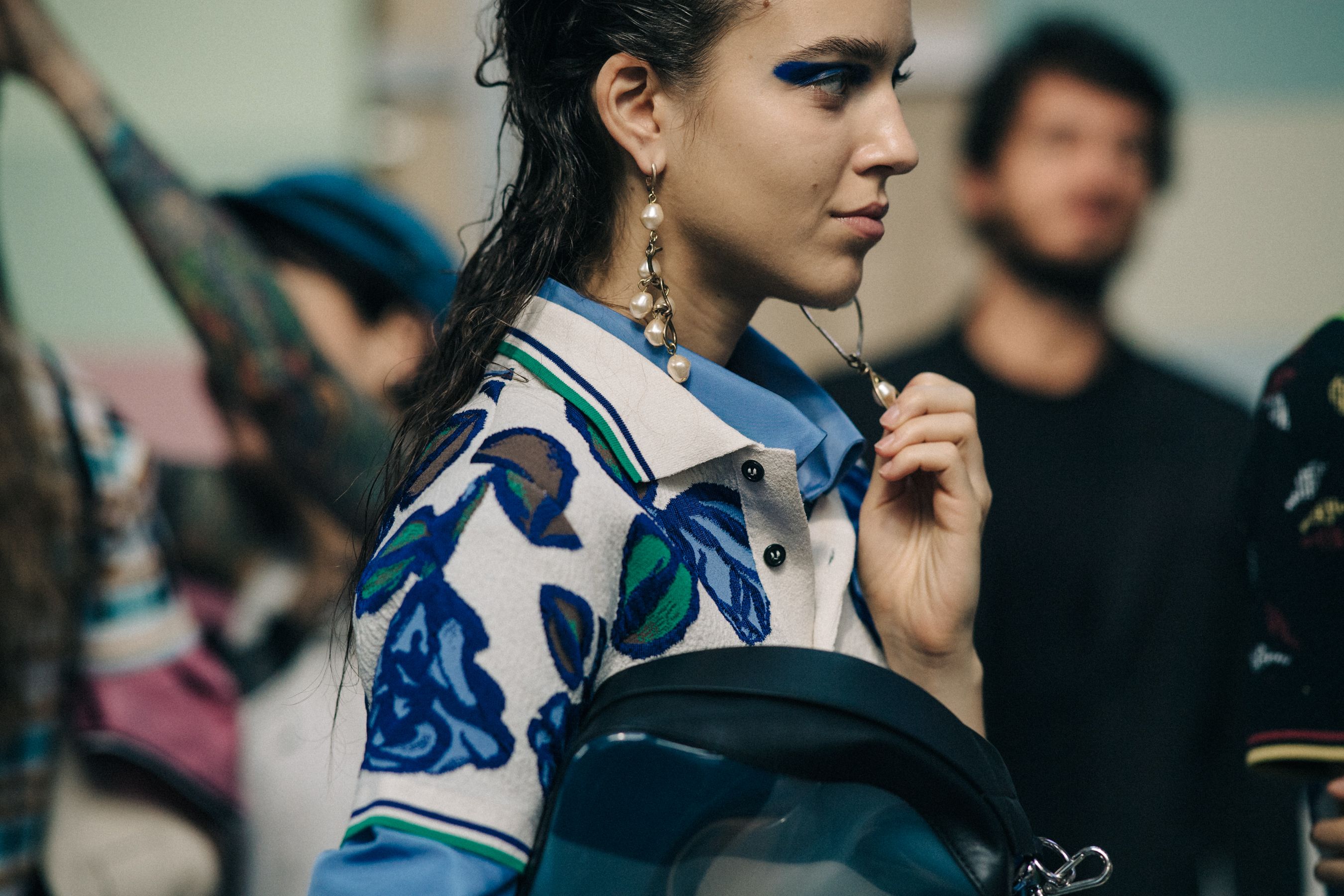 Model backstage wearing blue shirt under floral top