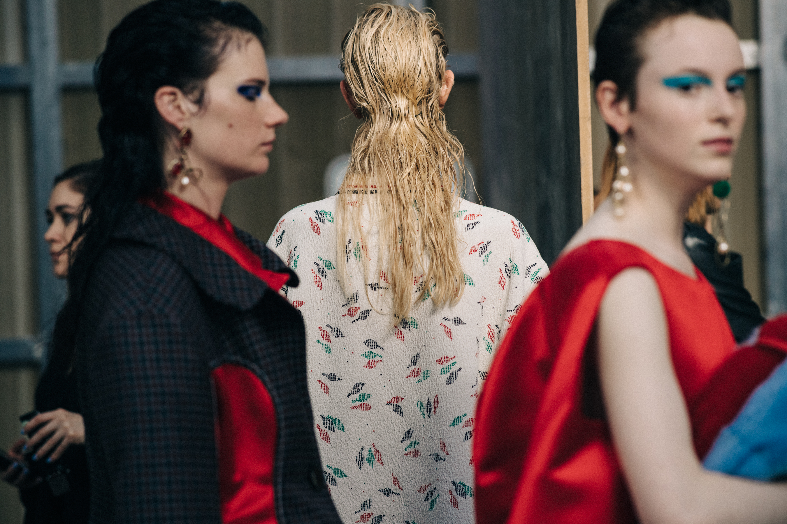 Model with blonde hair backstage in floral top